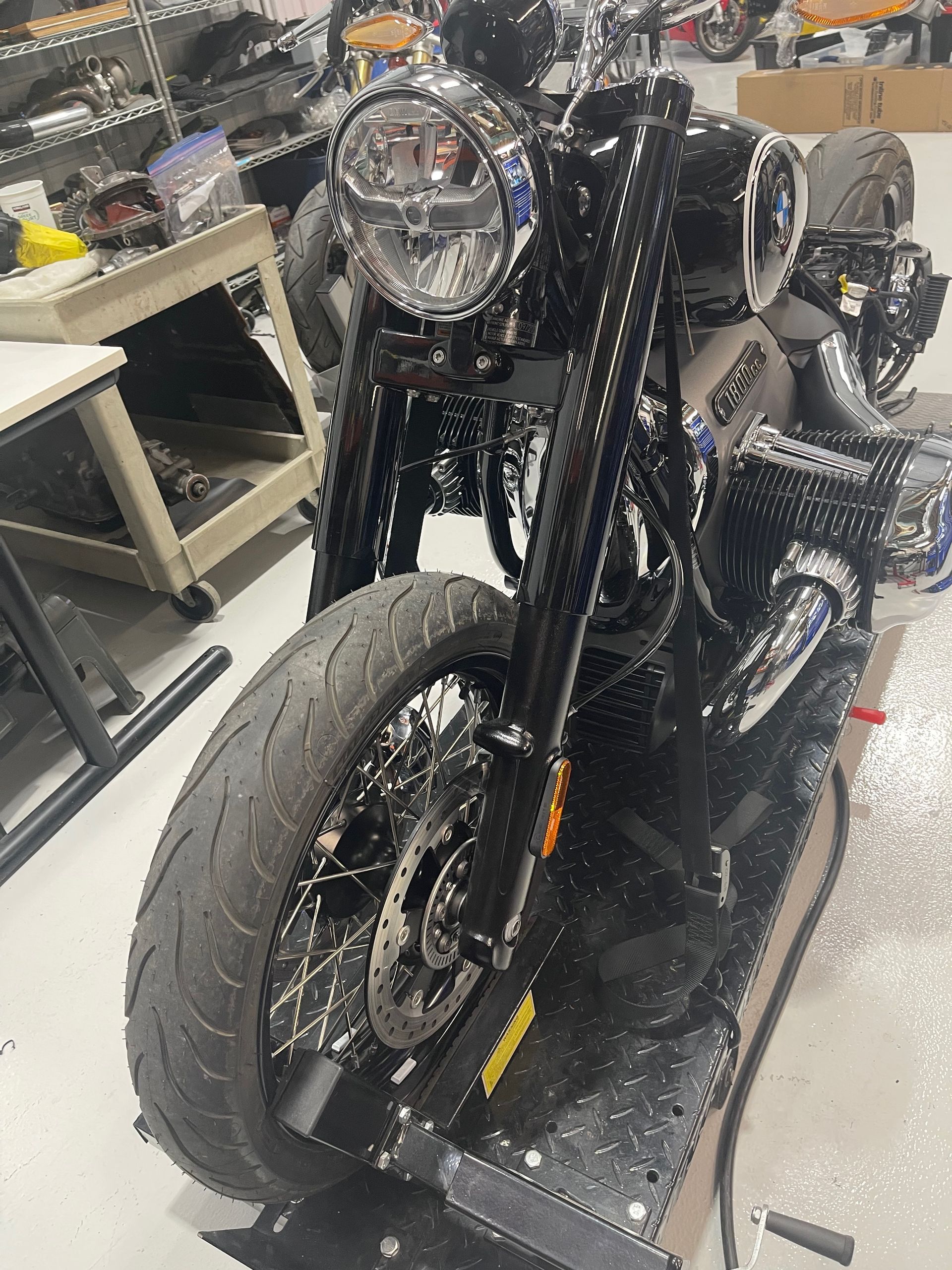 A black motorcycle is sitting on a table in a garage.
