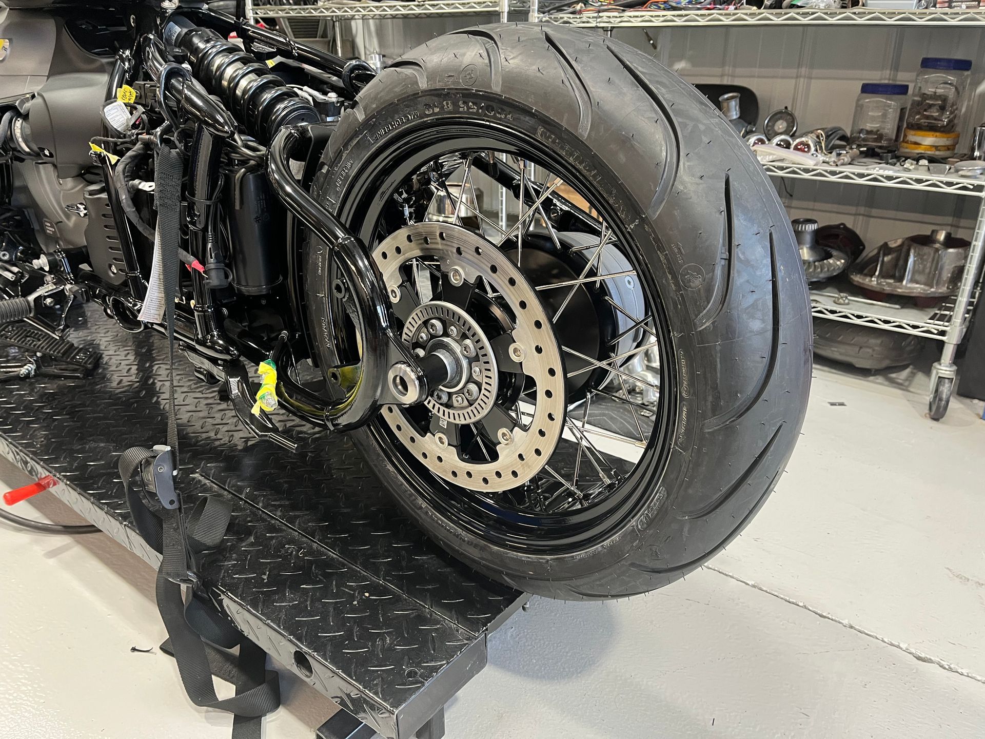 A motorcycle is sitting on a lift in a garage.