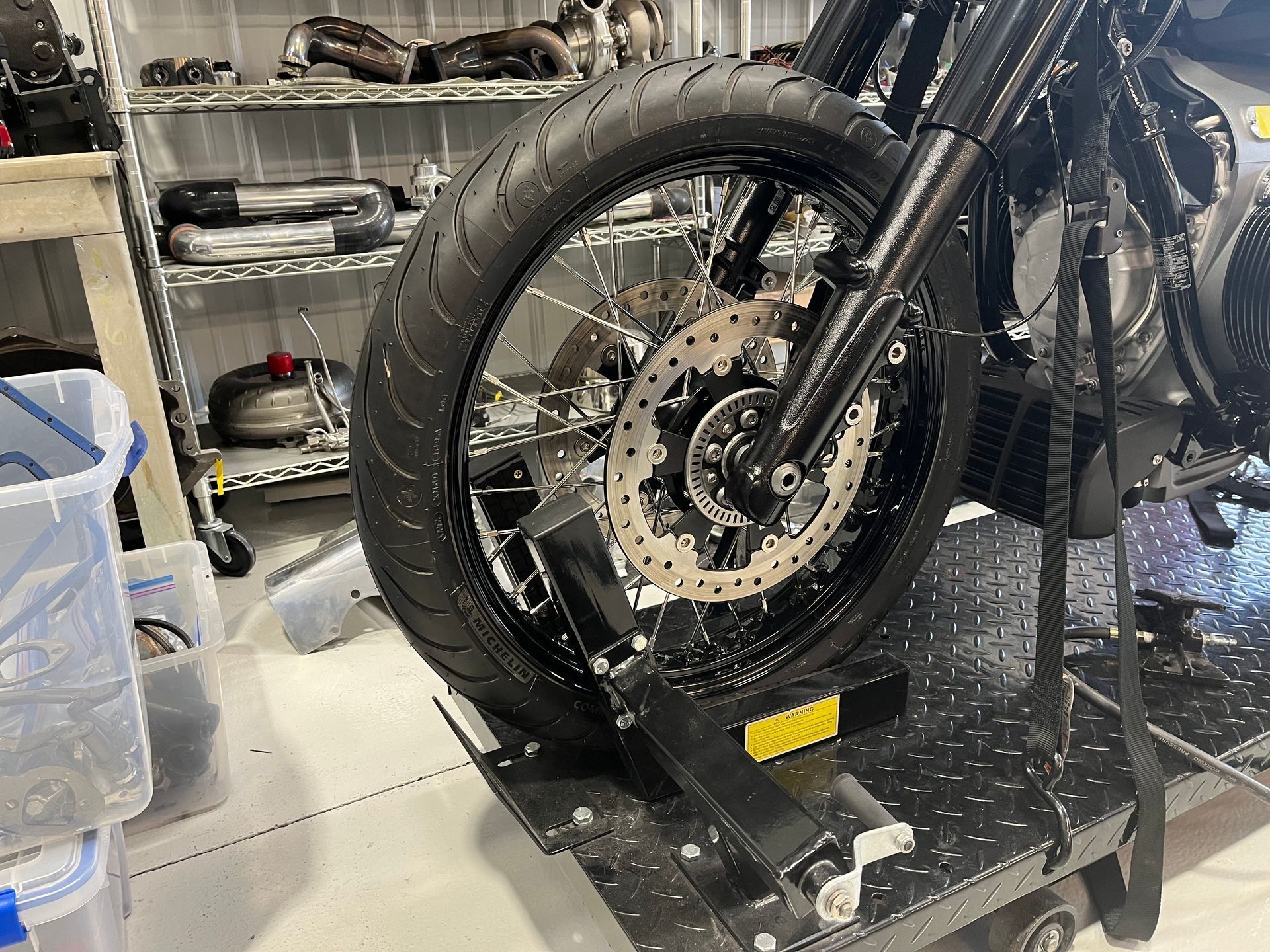 A motorcycle is sitting on top of a cart in a garage.