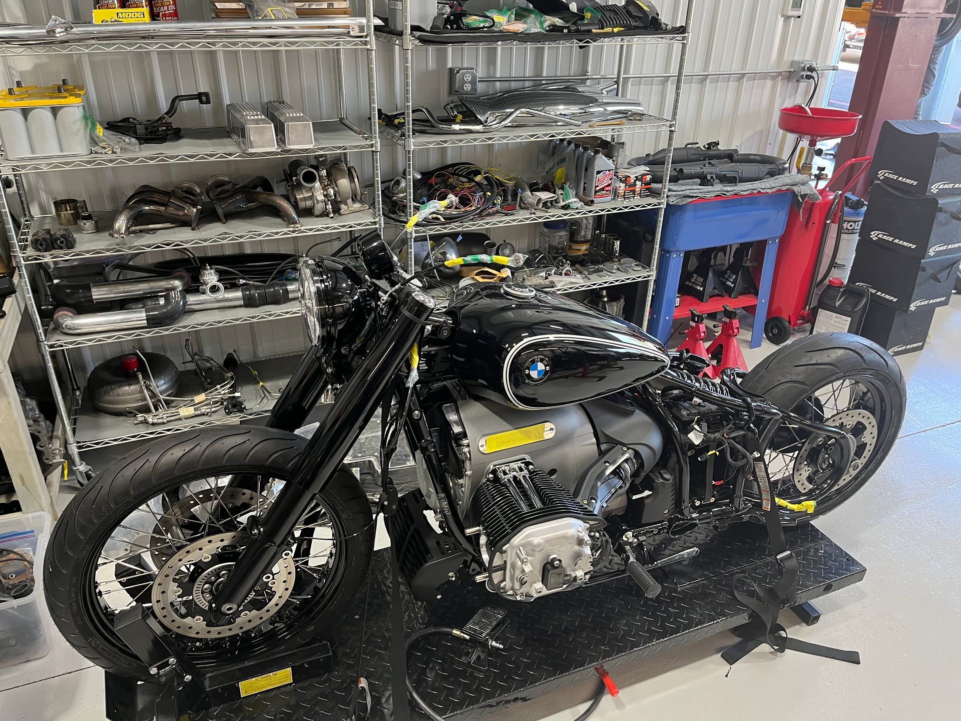 A motorcycle is sitting on a lift in a garage.