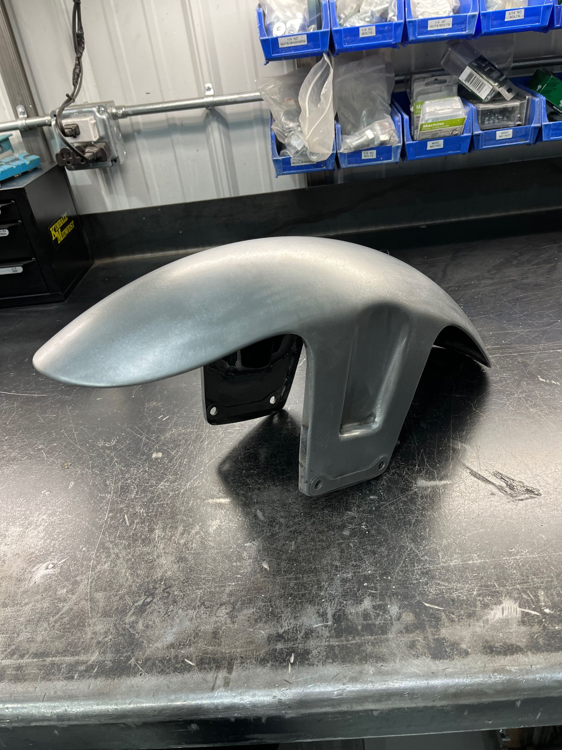 A motorcycle front fender is sitting on a table.