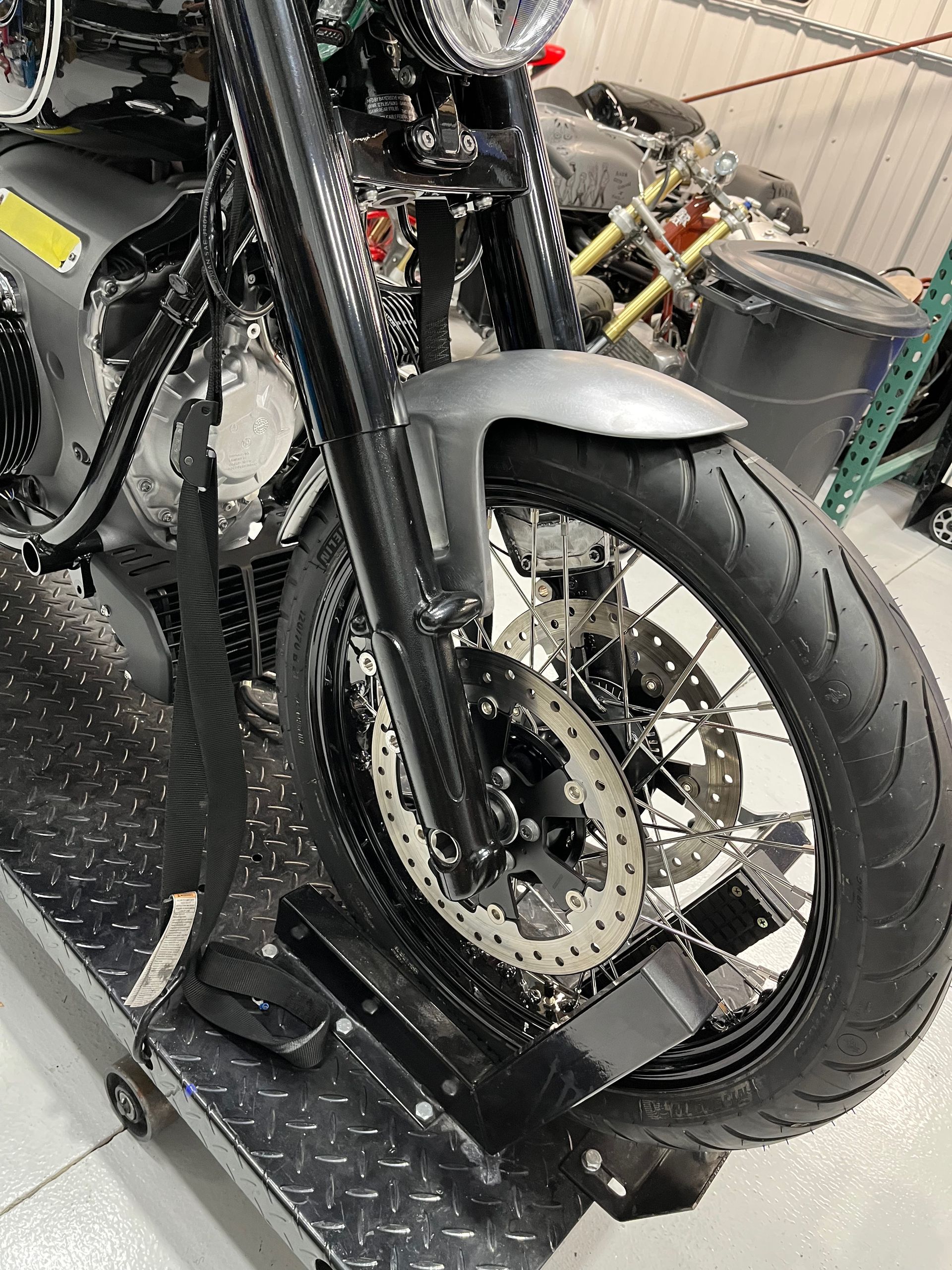 A motorcycle is sitting on a scale in a garage.