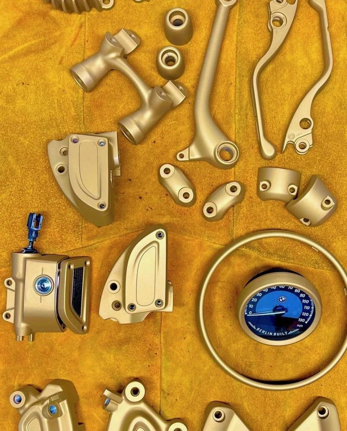 A bunch of motorcycle parts on a yellow cloth