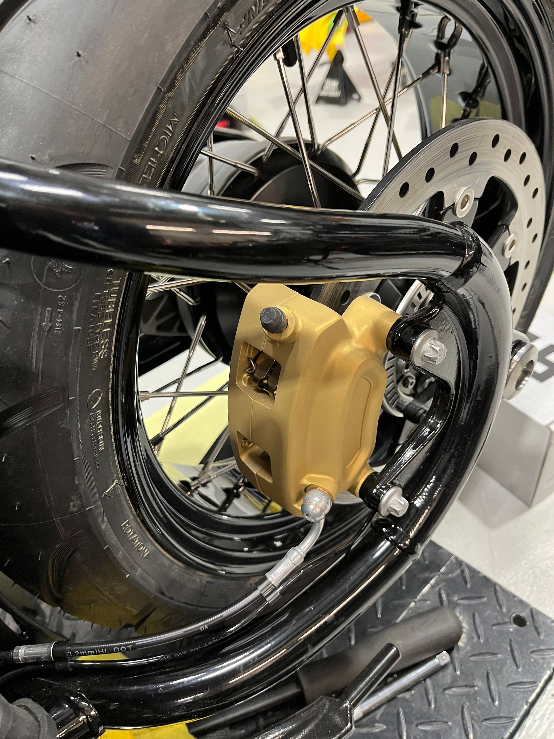 A close up of a motorcycle wheel with a brake caliper on it.
