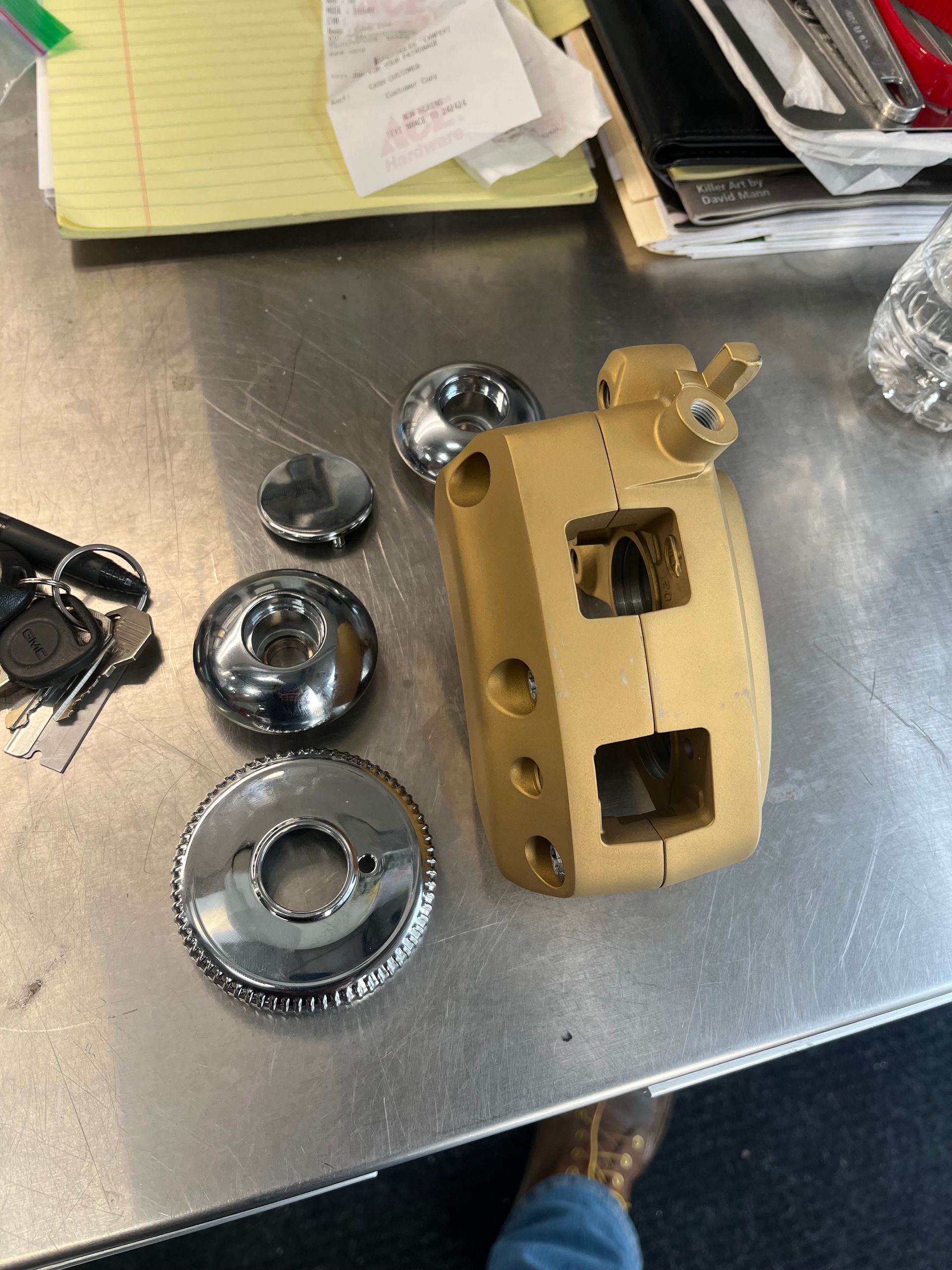 A person is standing next to a piece of metal on a table.