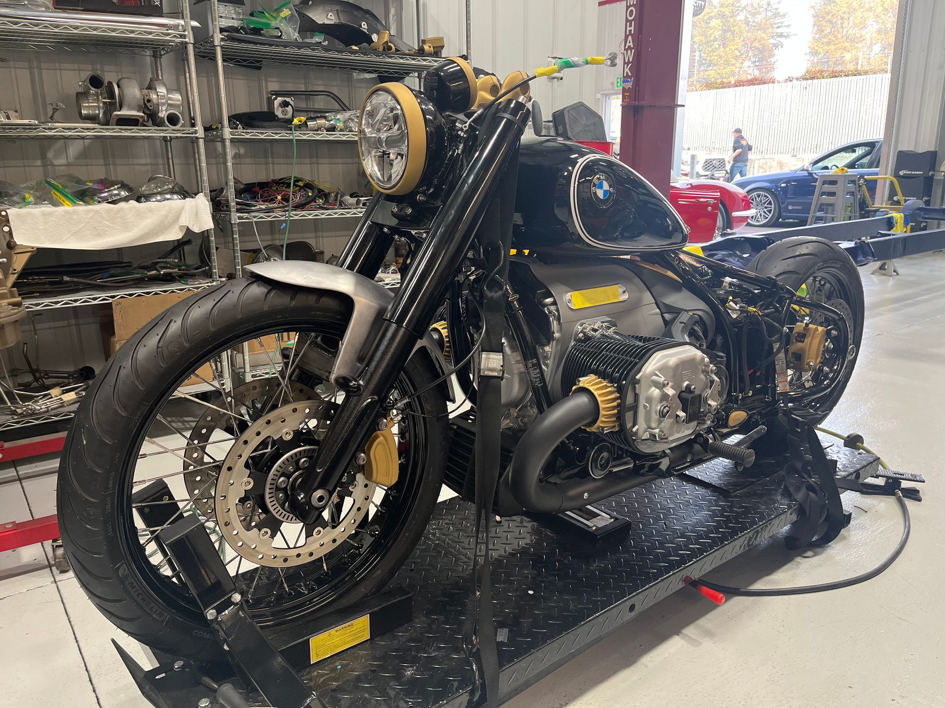 A motorcycle is sitting on a lift in a garage.