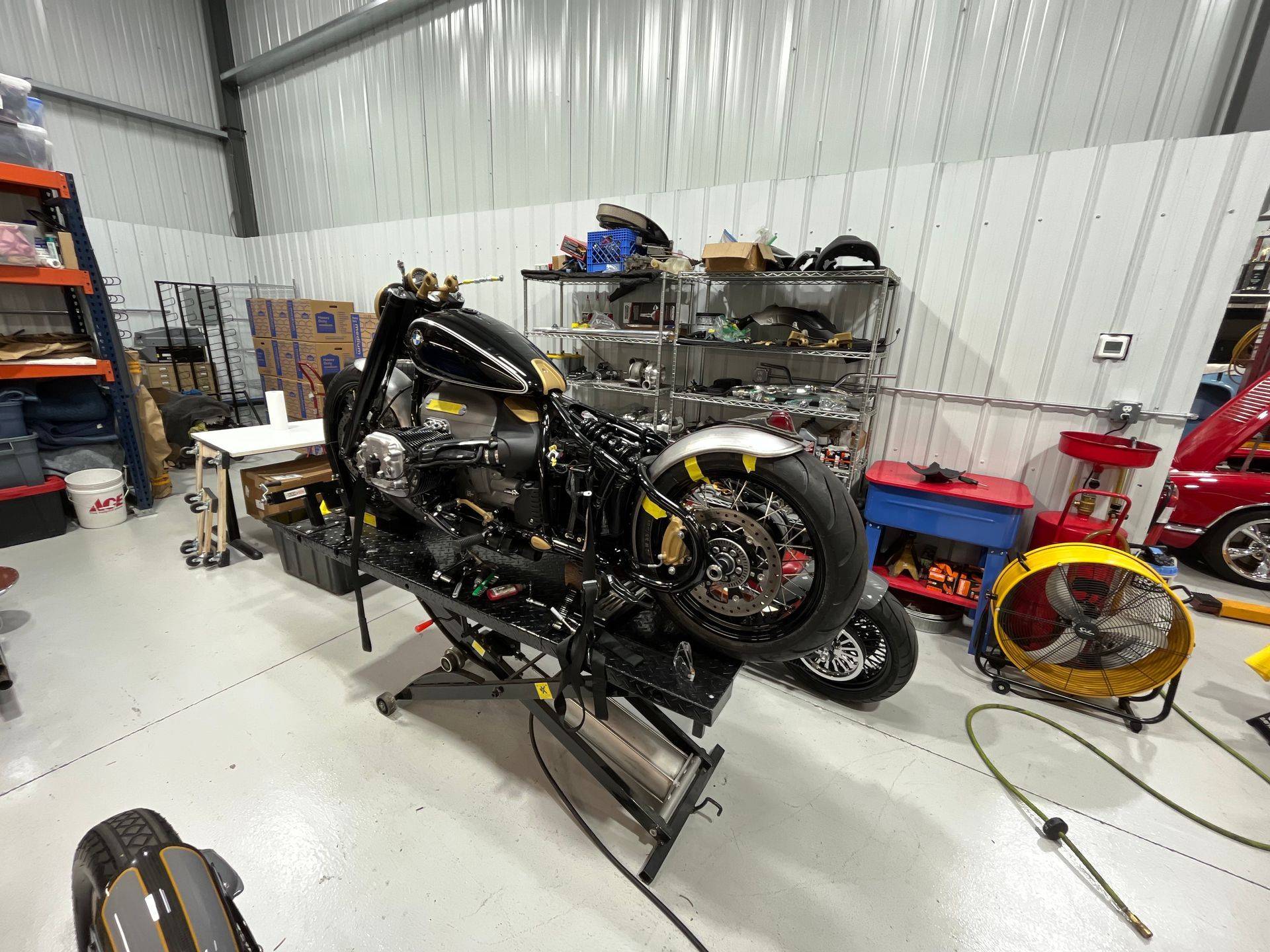 A motorcycle is sitting on a lift in a garage.
