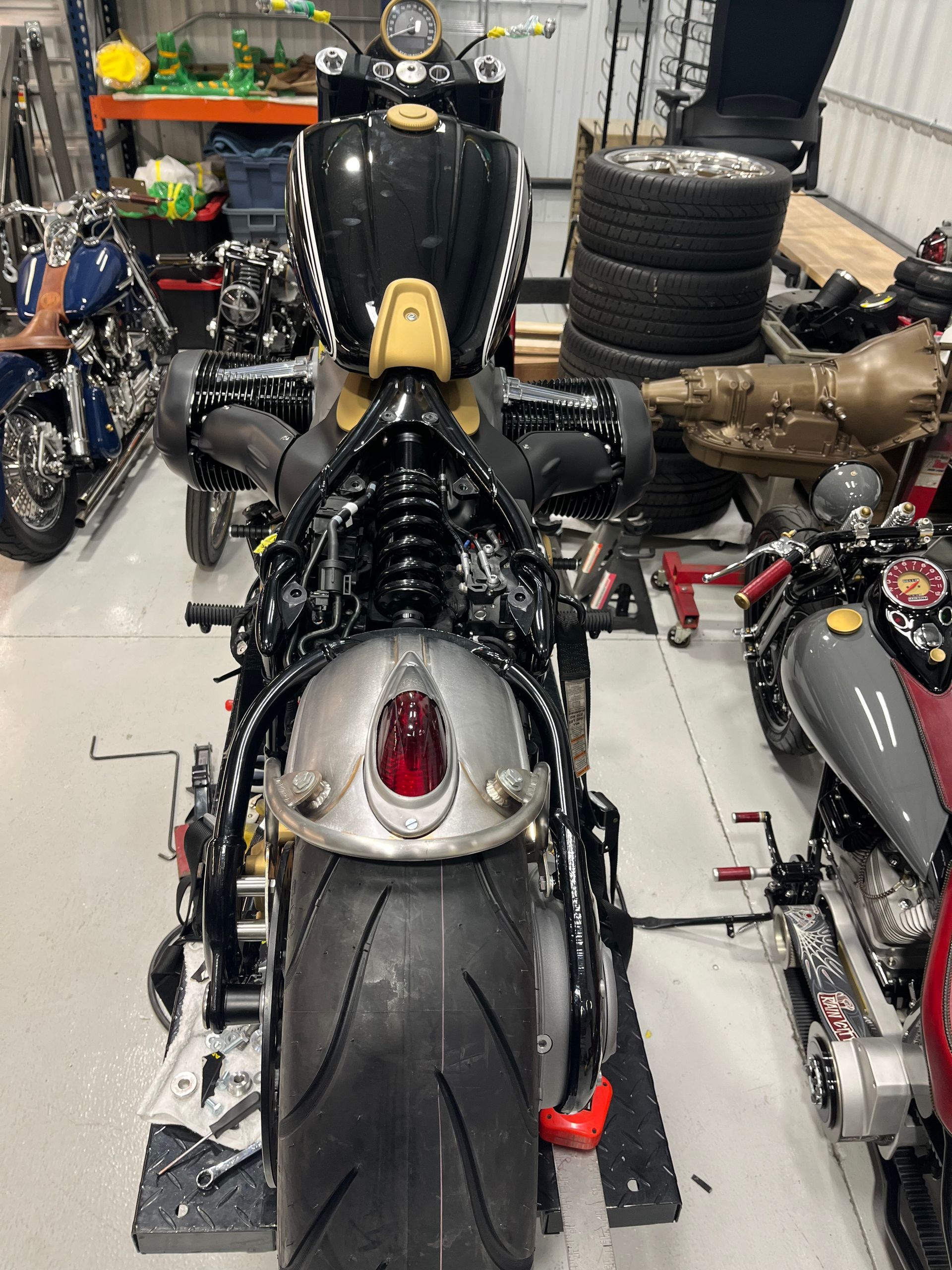 A motorcycle is parked in a garage surrounded by other motorcycles.