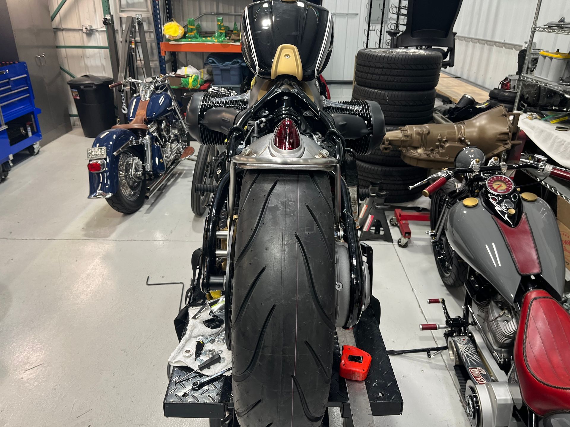 A motorcycle is sitting on a lift in a garage.