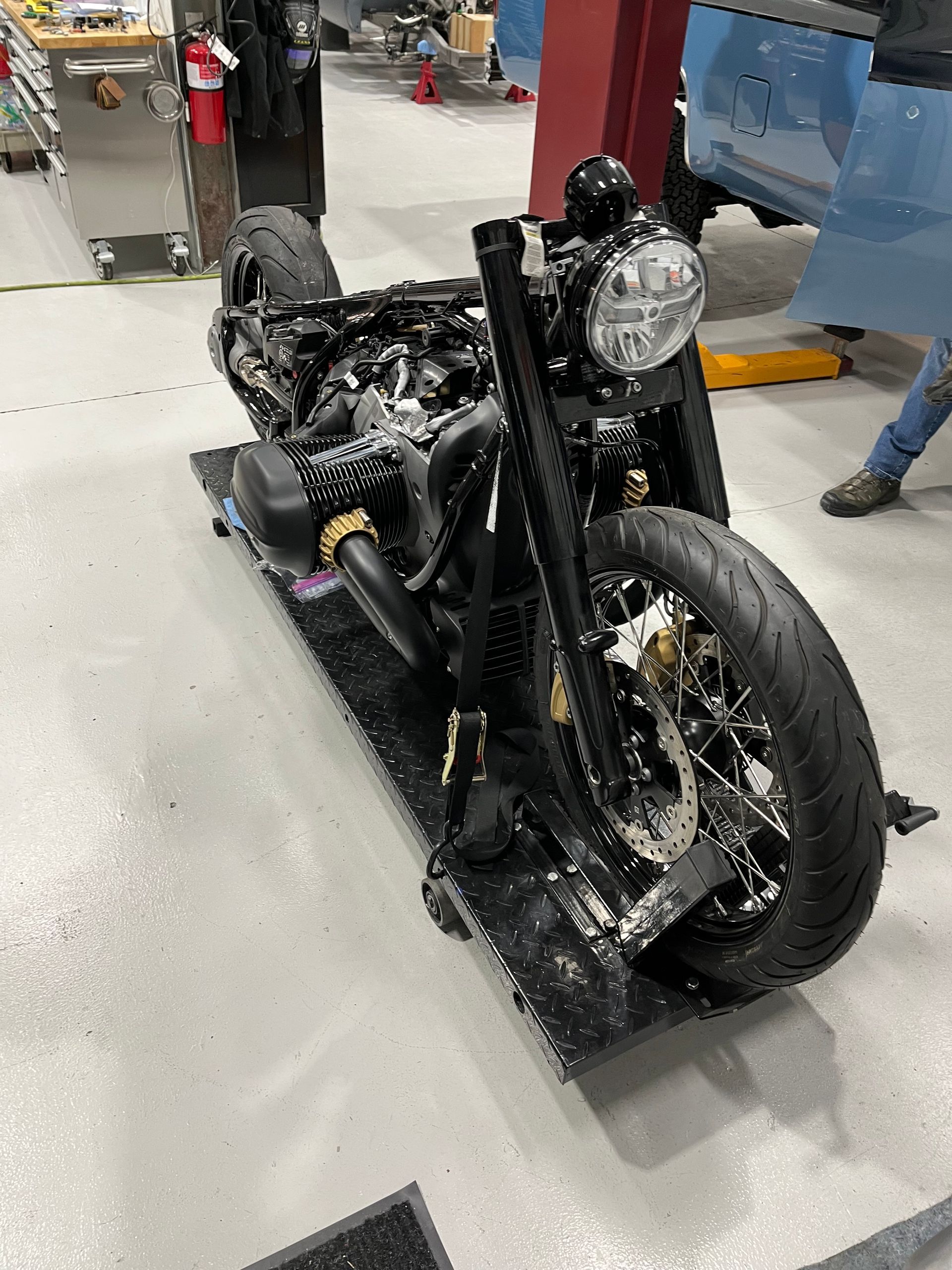 A motorcycle is sitting on a ramp in a garage.