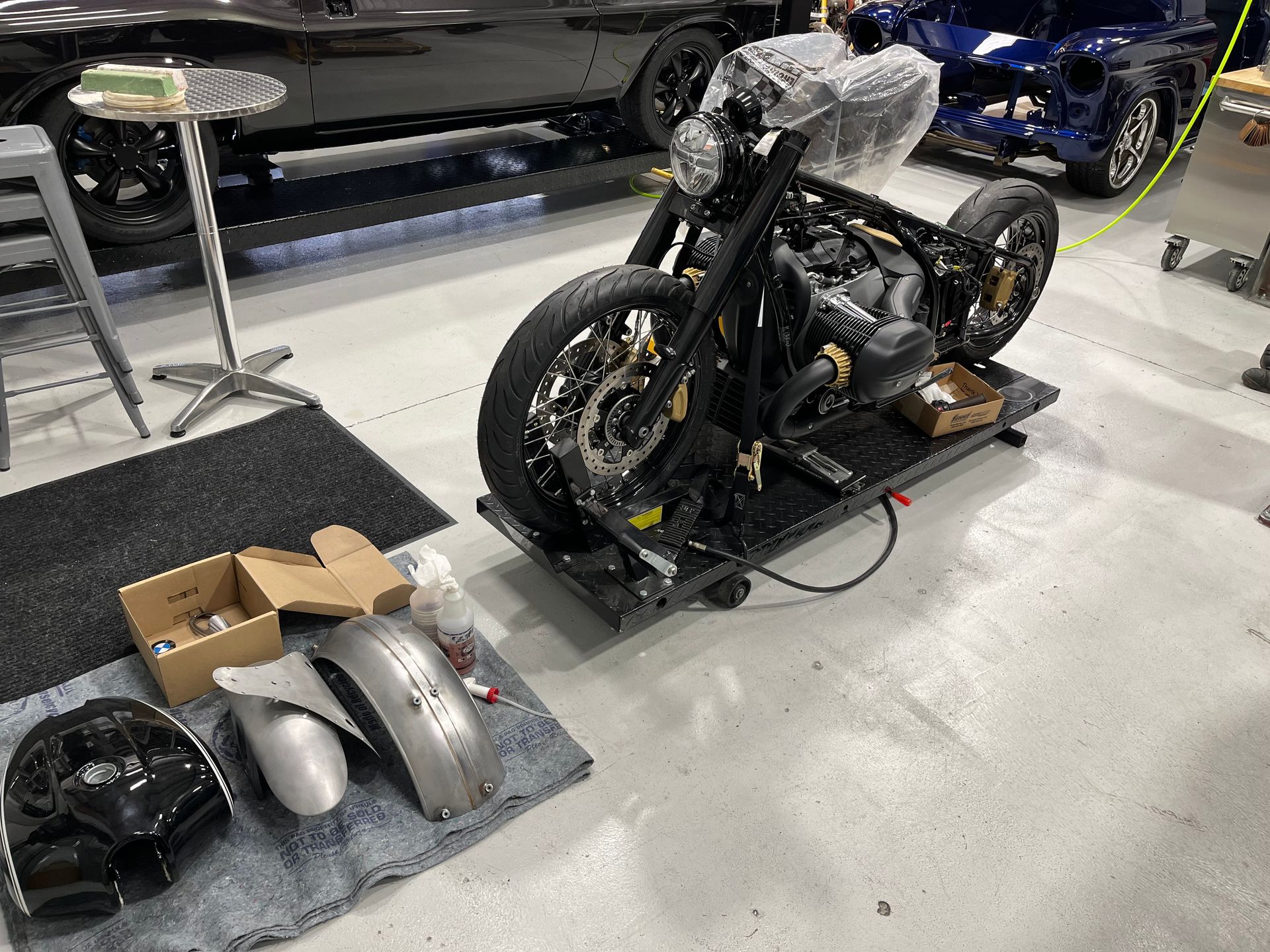 A motorcycle is sitting on top of a cart in a garage.
