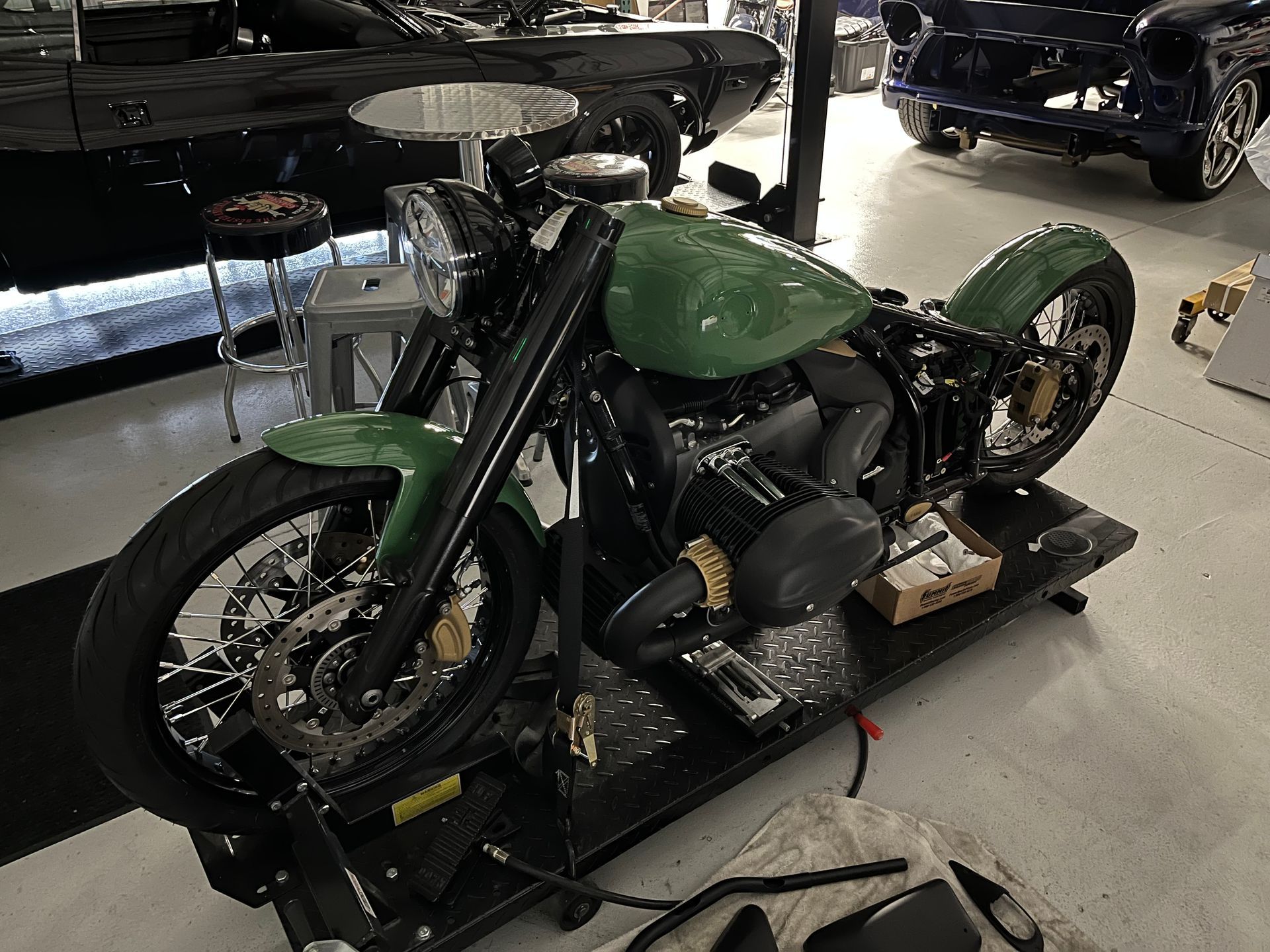 A green motorcycle is on display in a garage