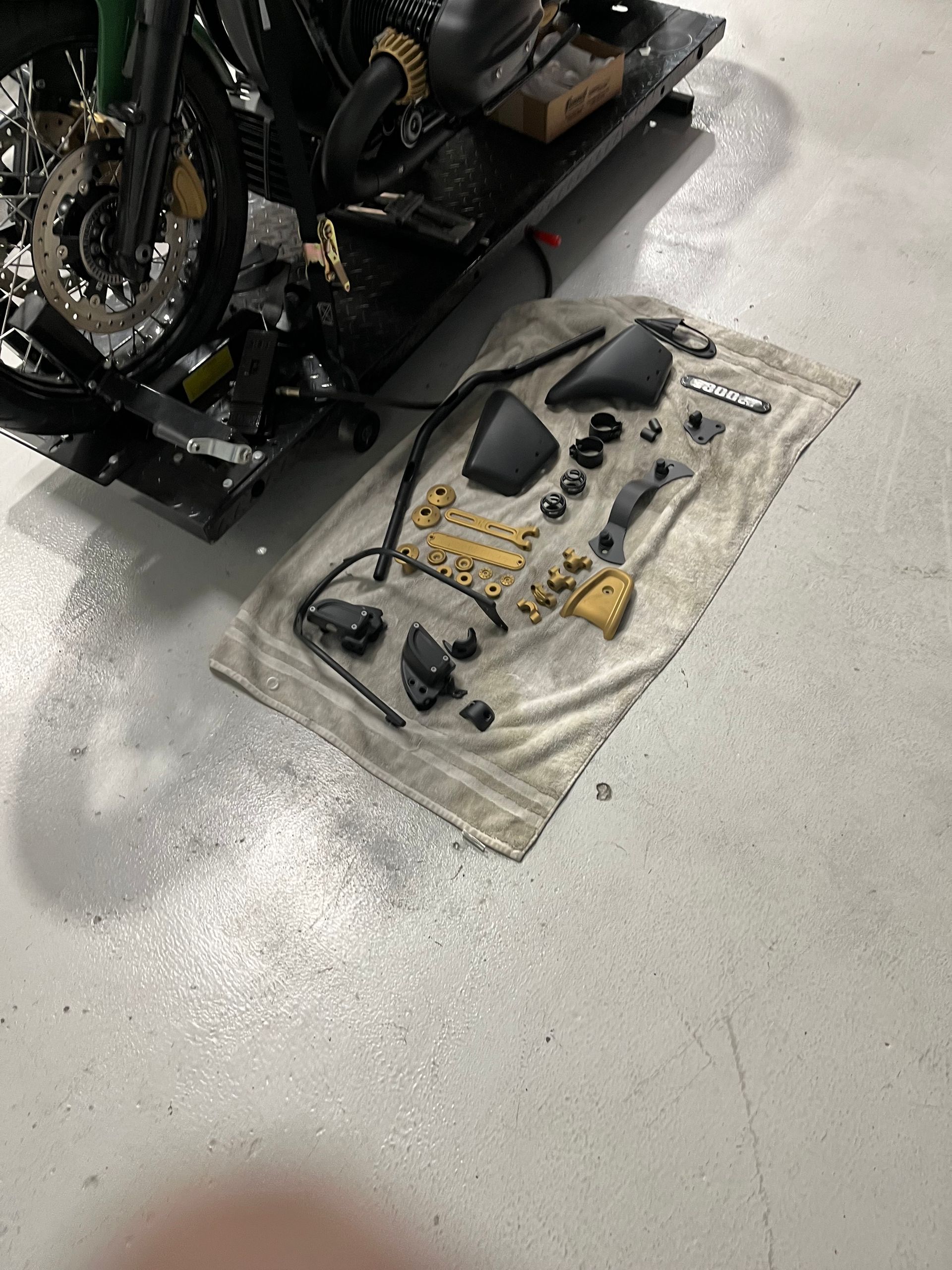 A motorcycle is sitting on top of a towel on the floor.