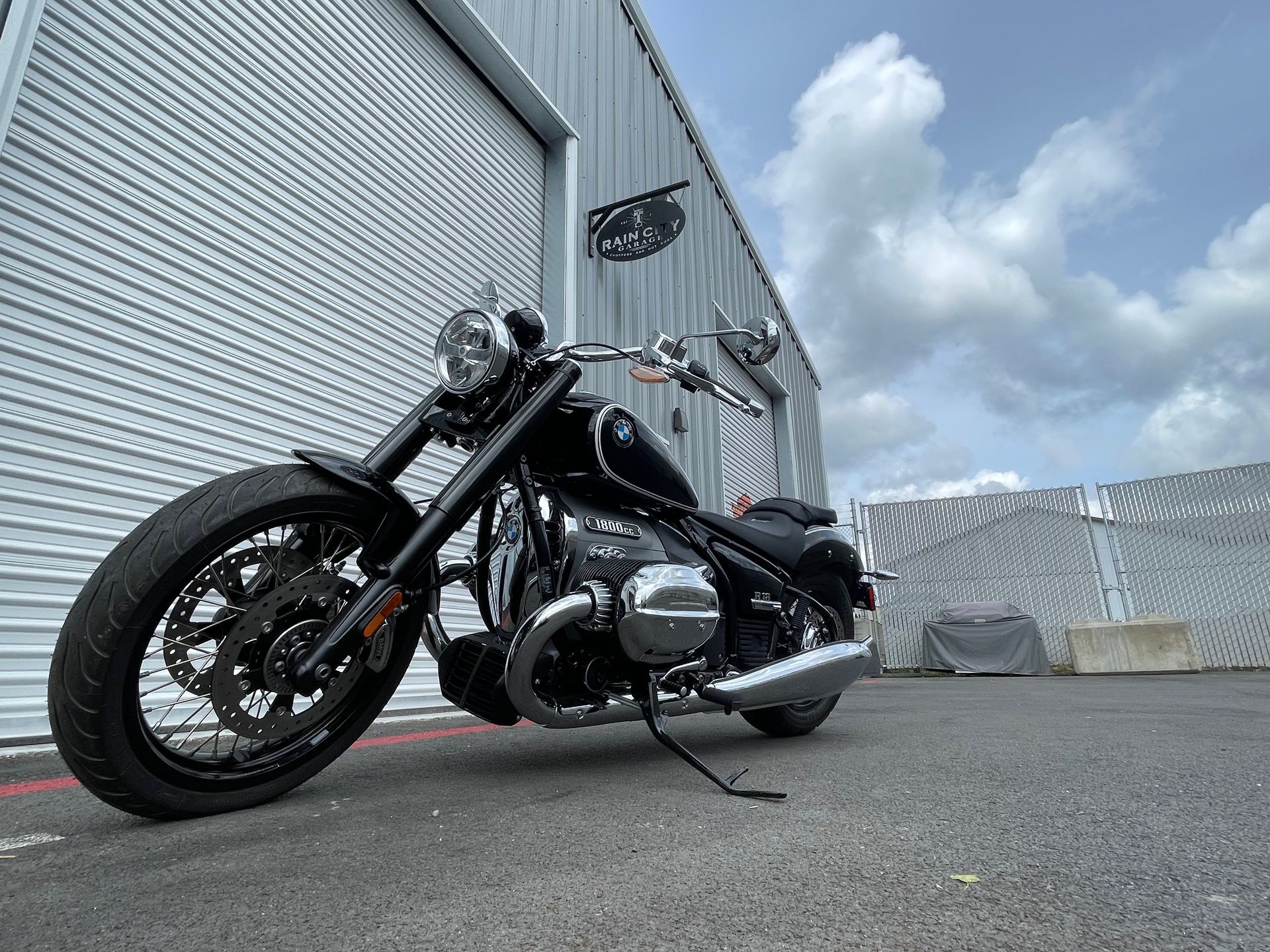 A black motorcycle is parked in front of a building.