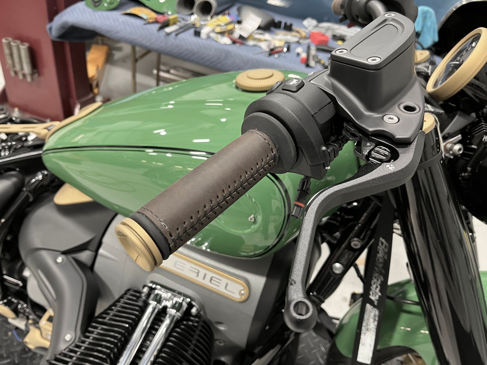 A close up of a green motorcycle with a brown handlebar grip