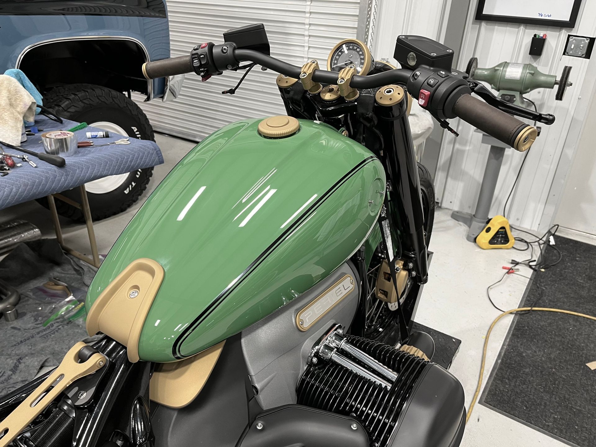 A green and gold motorcycle is sitting in a garage.