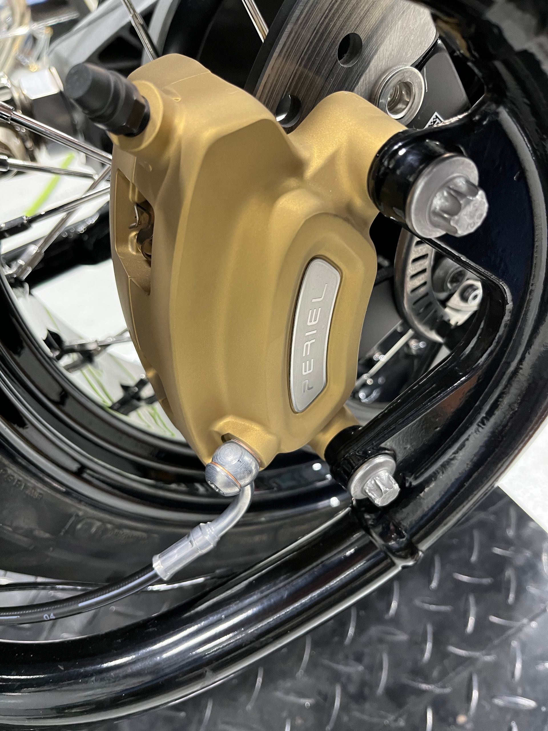 A close up of a brake caliper on a motorcycle wheel.