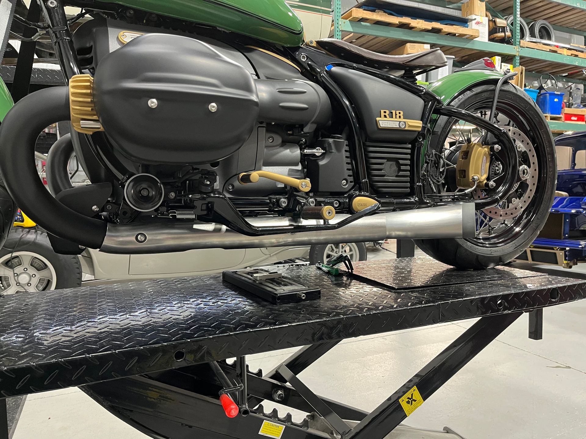 A motorcycle is sitting on a lift in a garage.