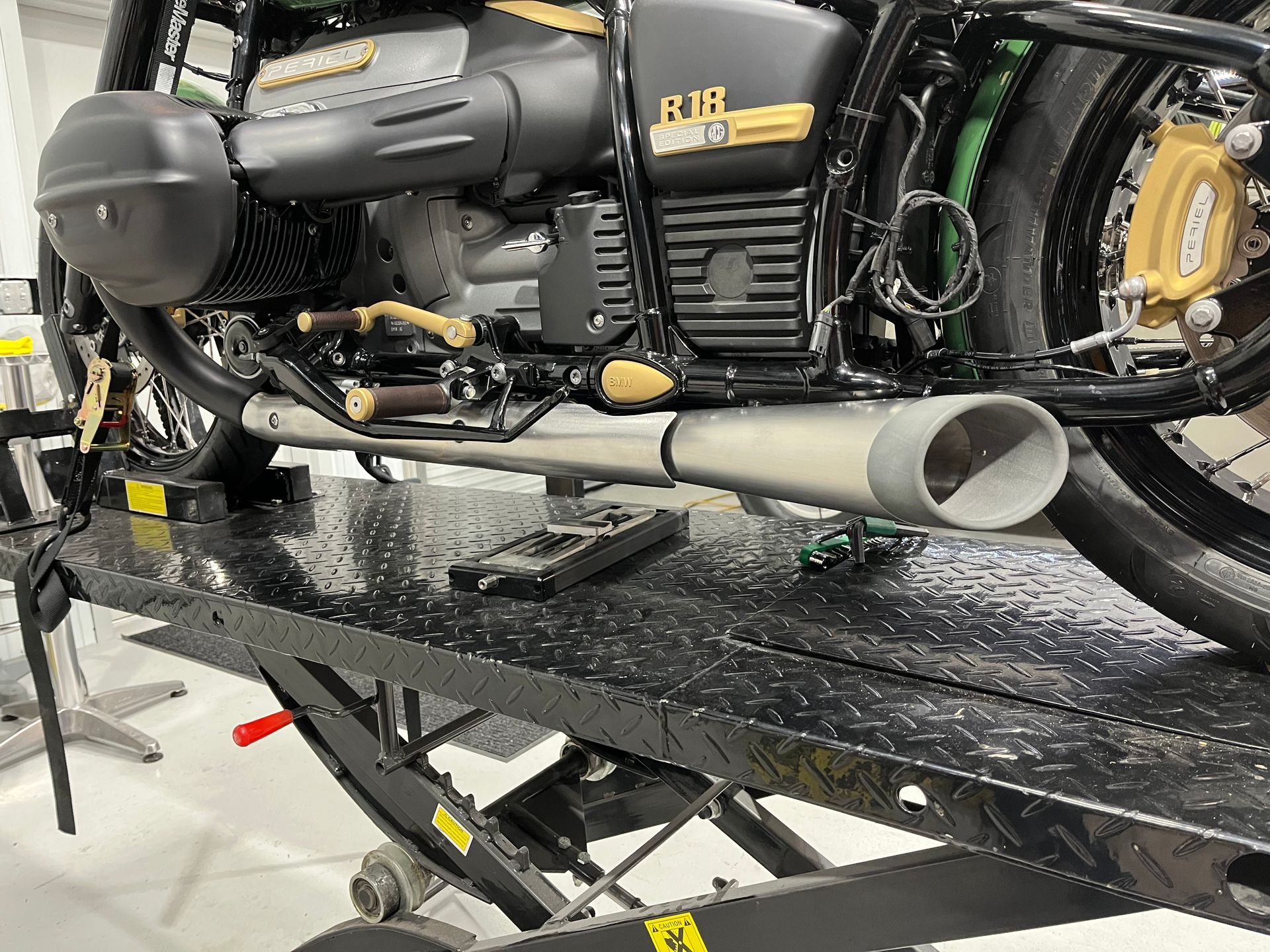 A motorcycle is sitting on a lift in a garage.