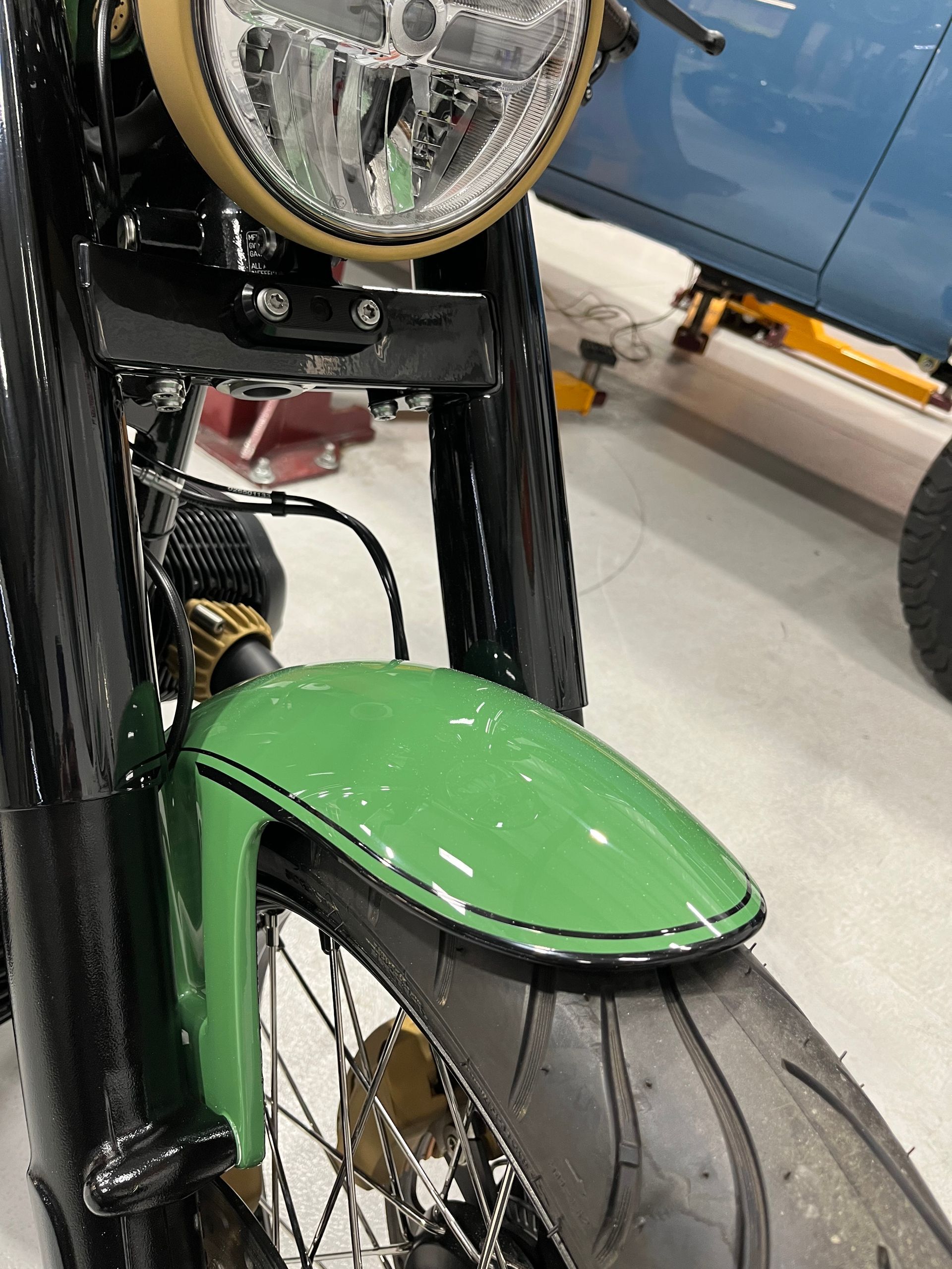 A motorcycle with a green front fender and a yellow headlight