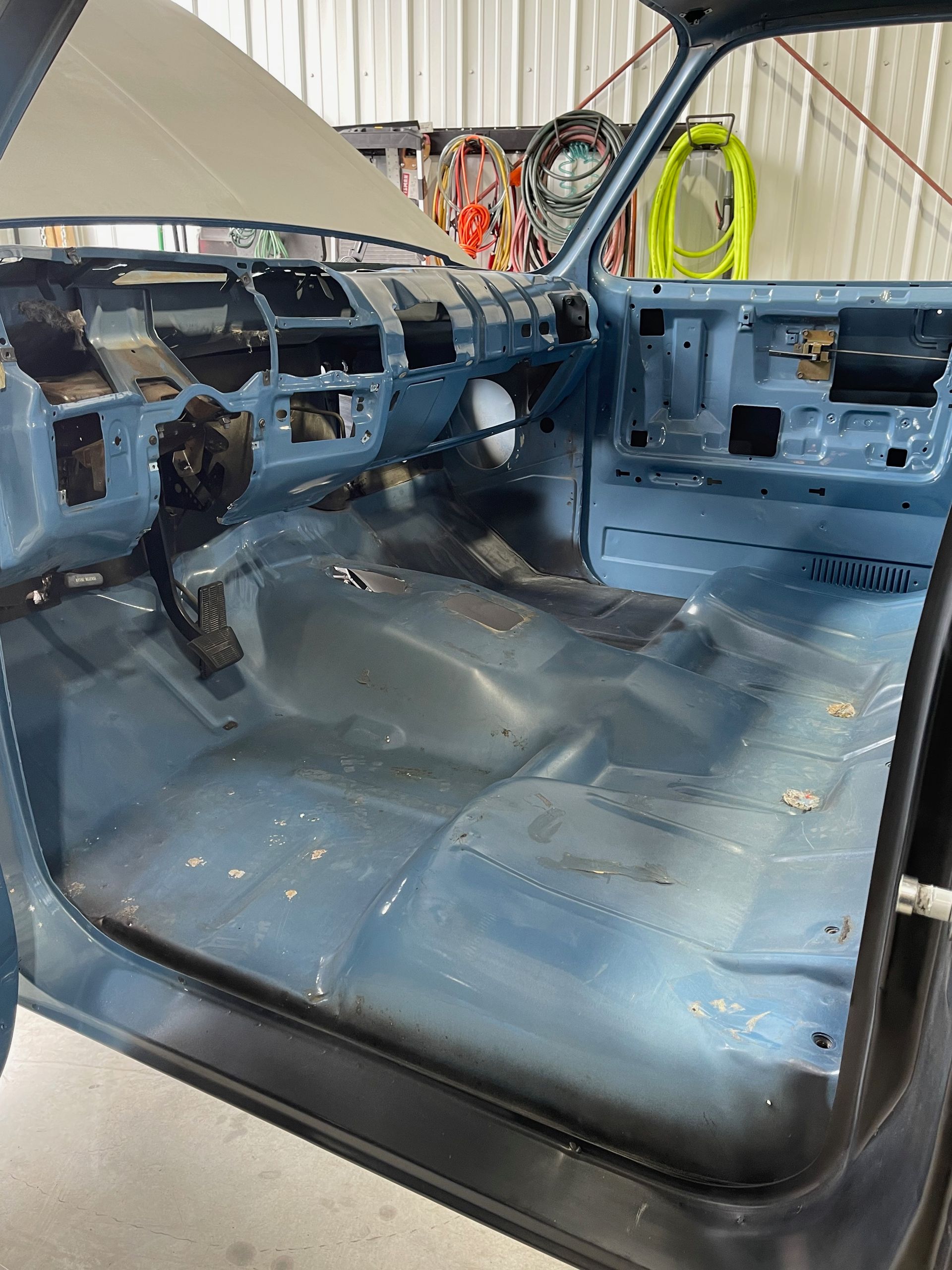 The inside of a blue car with the door open.
