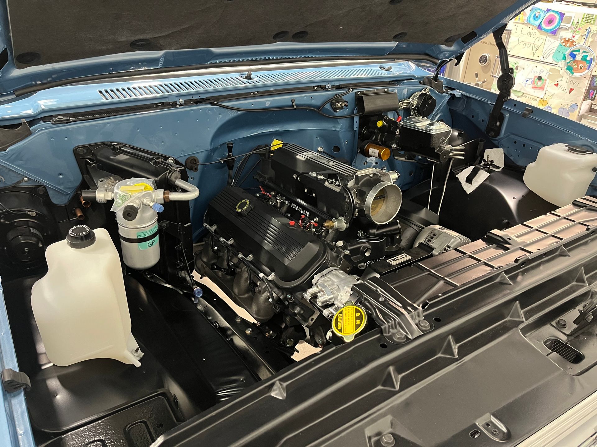 A close up of a car engine with the hood open.