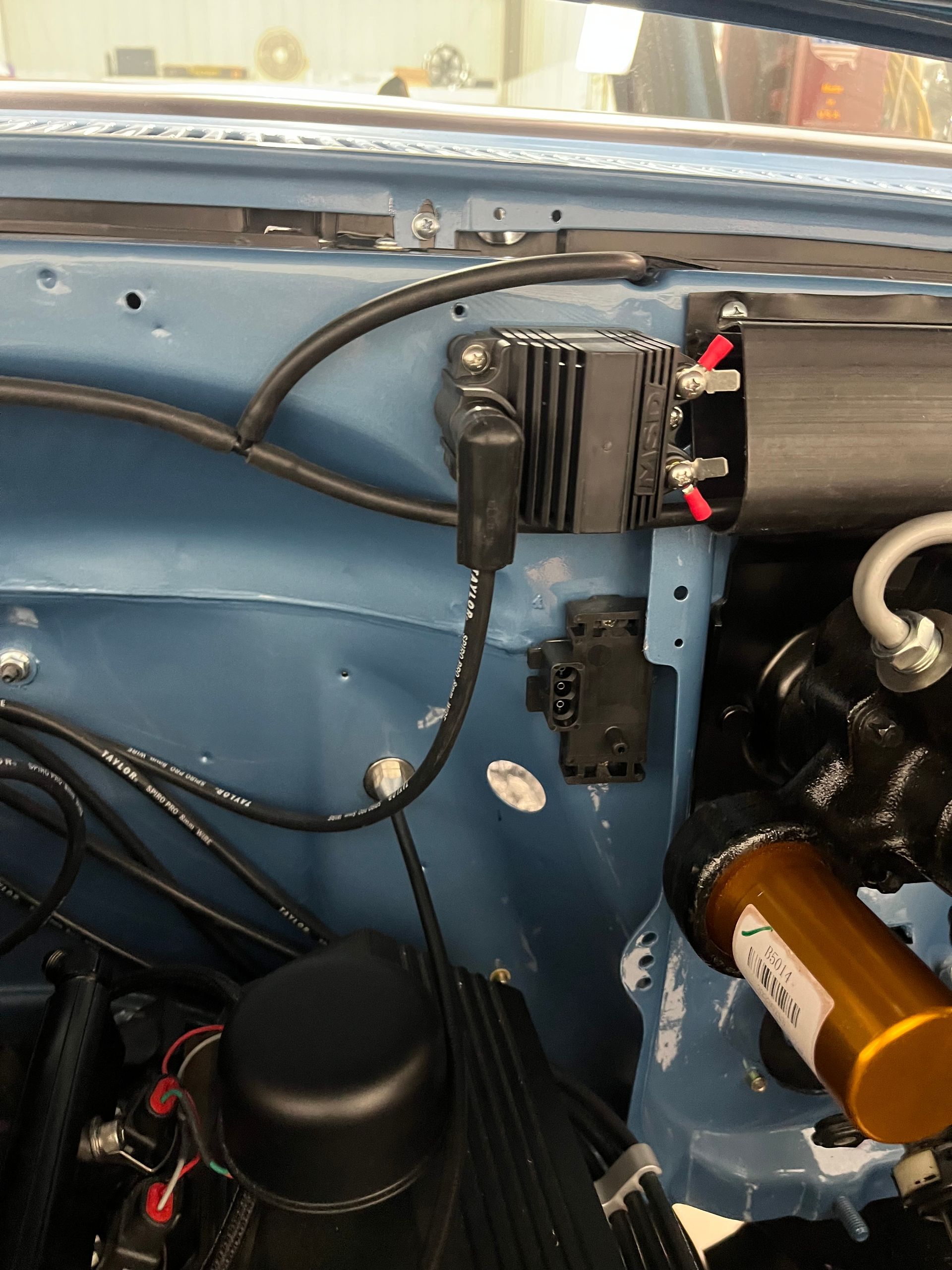 A close up of a blue car engine with a few wires coming out of it