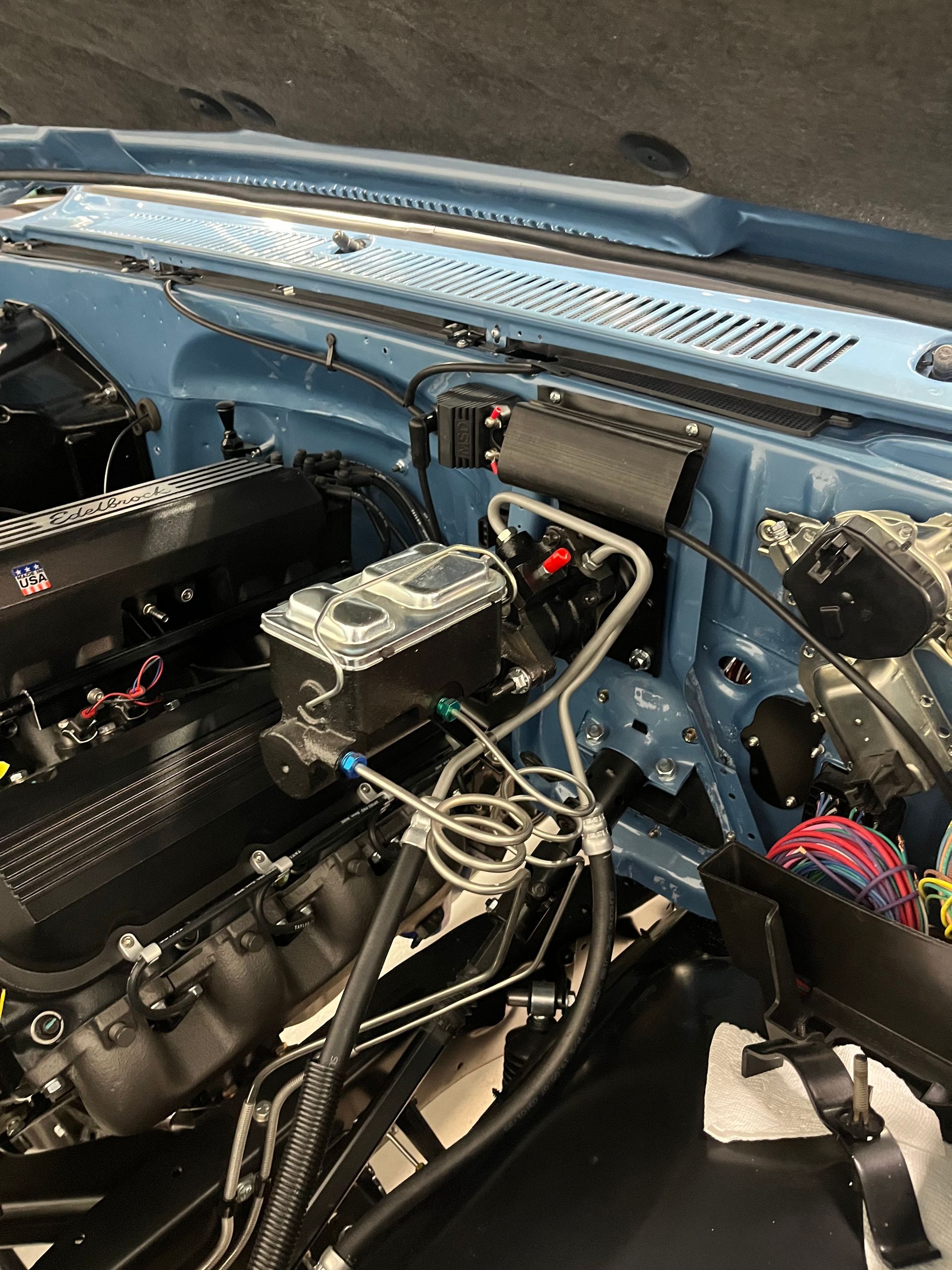 A close up of a car engine with the hood open