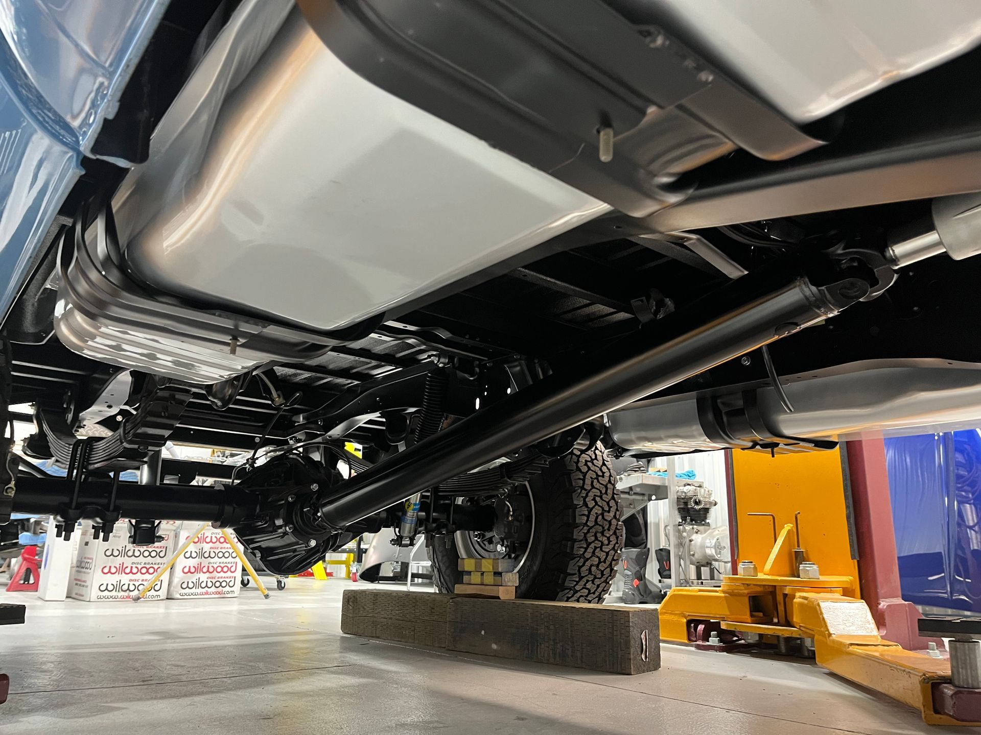 The underside of a truck is shown in a garage.