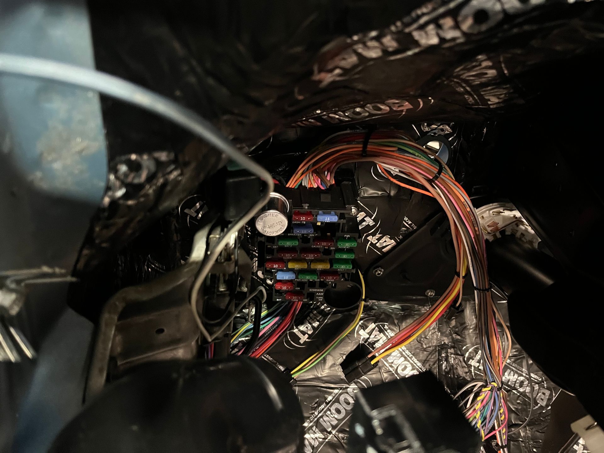 A bunch of wires are connected to a fuse box in a car.