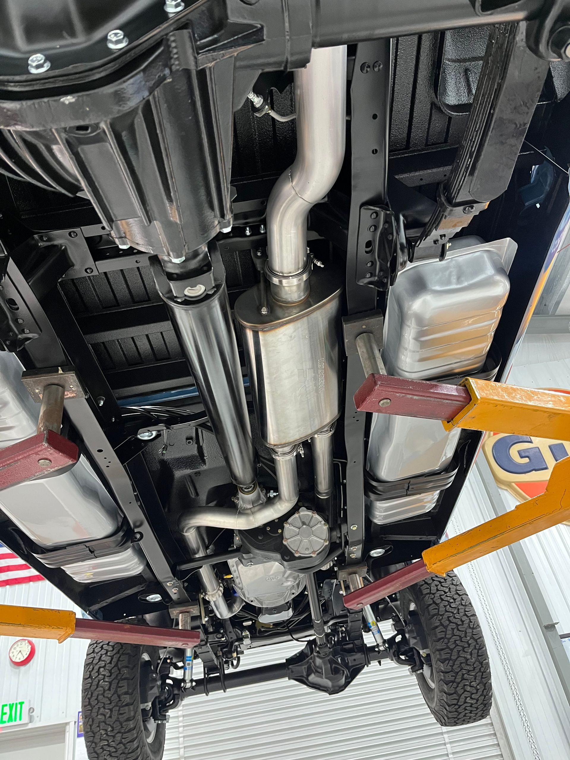 A close up of the underside of a truck on a lift.