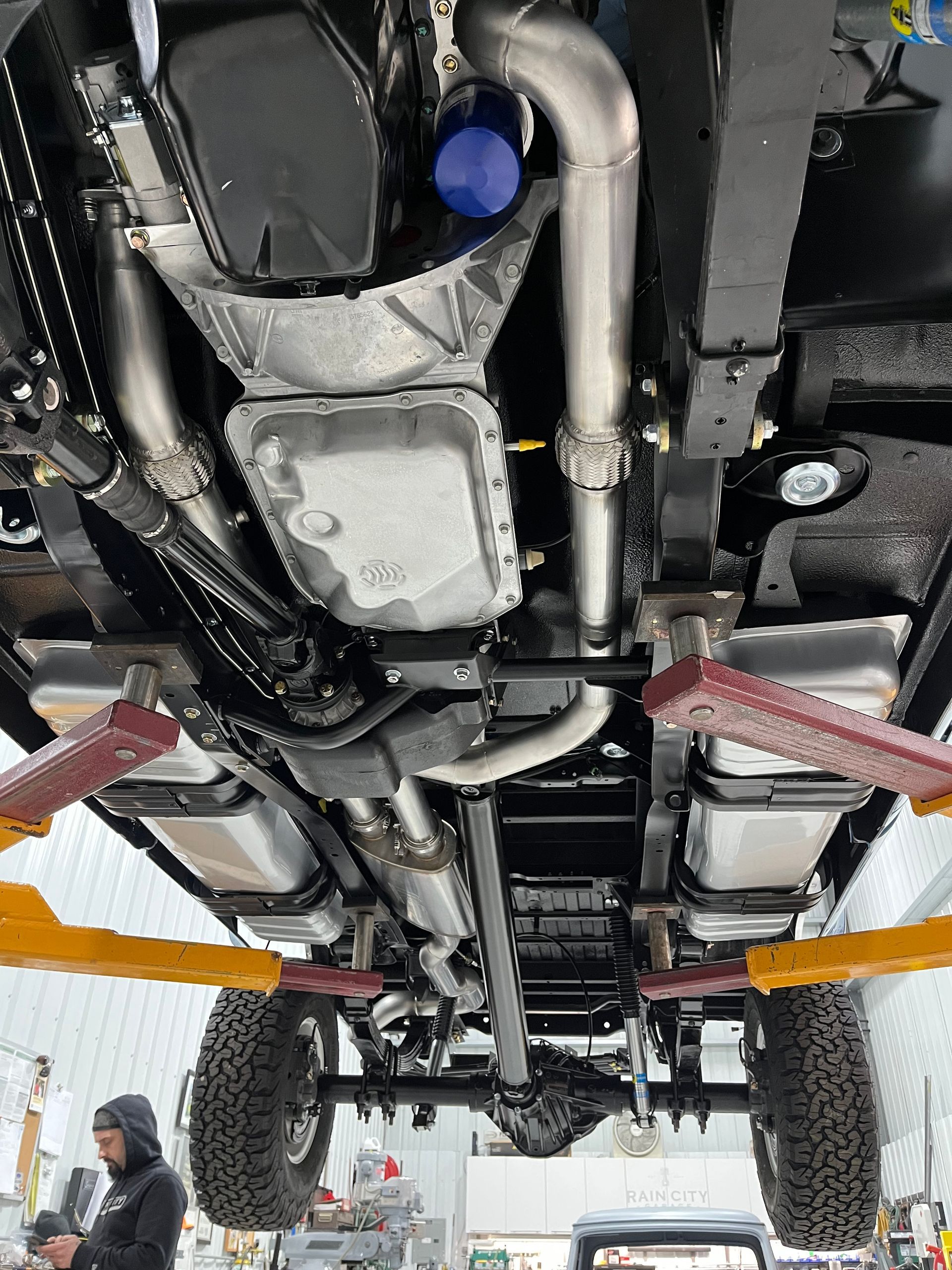 The underside of a truck is being lifted on a lift.