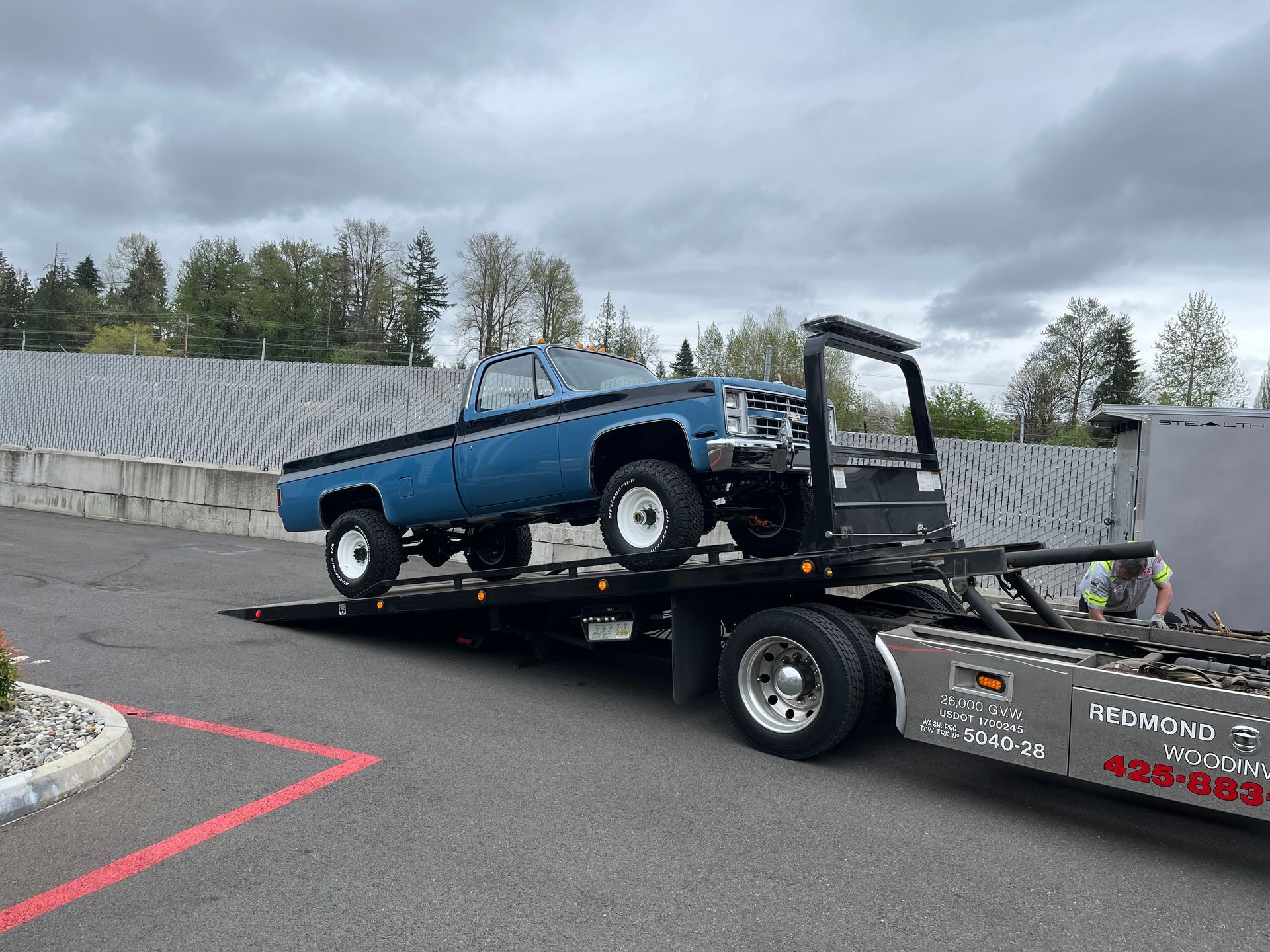 A blue truck is being towed by a tow truck.