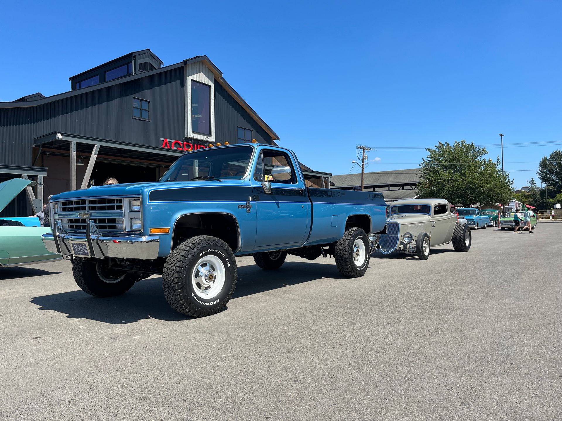 A blue truck is parked in front of a building.