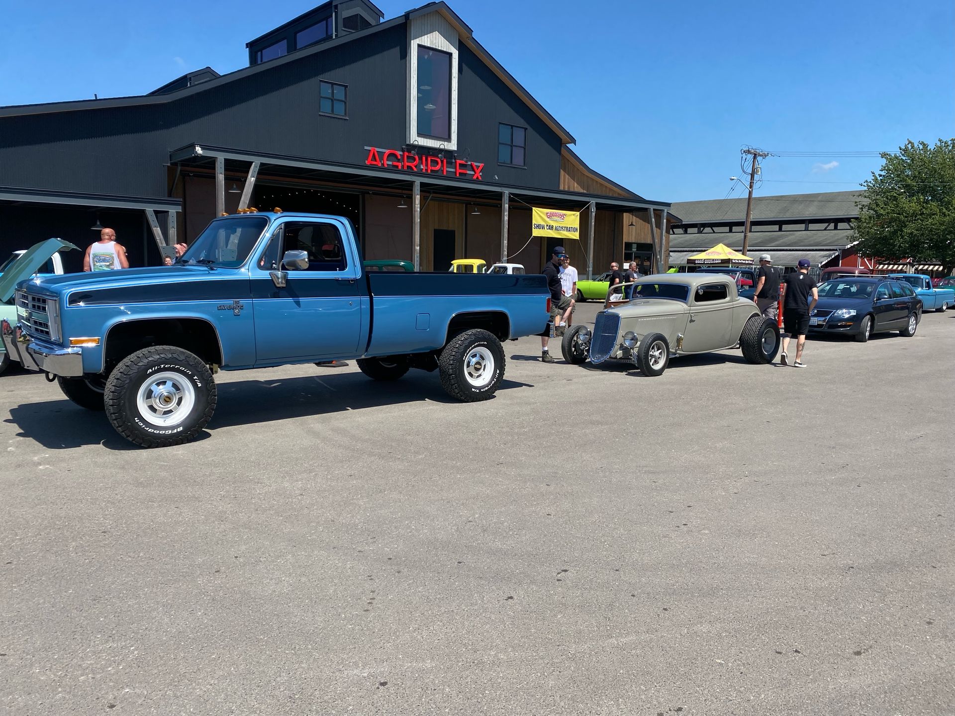 A blue truck is parked in front of a building