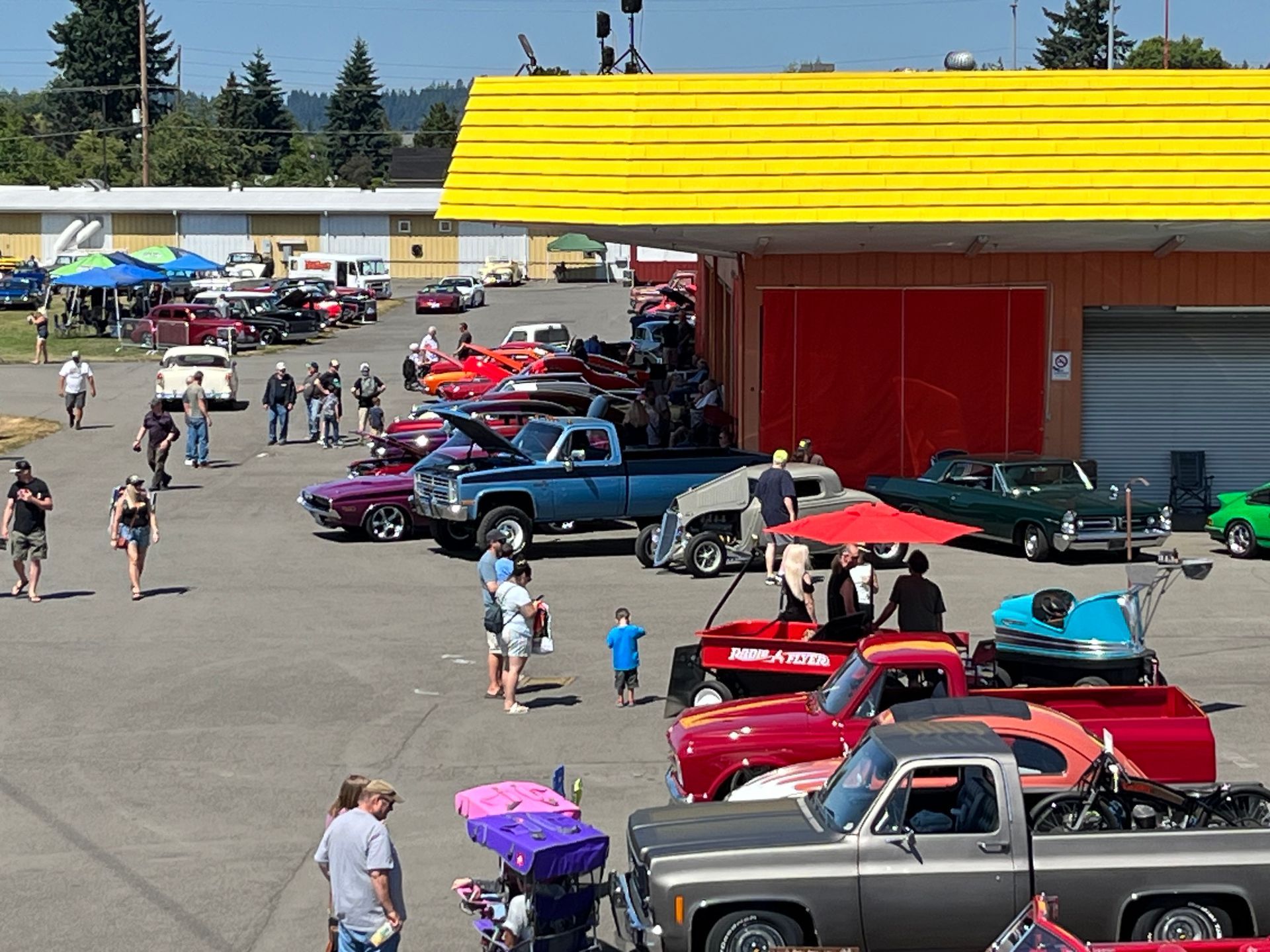 A lot of cars are parked in front of a building with a yellow roof