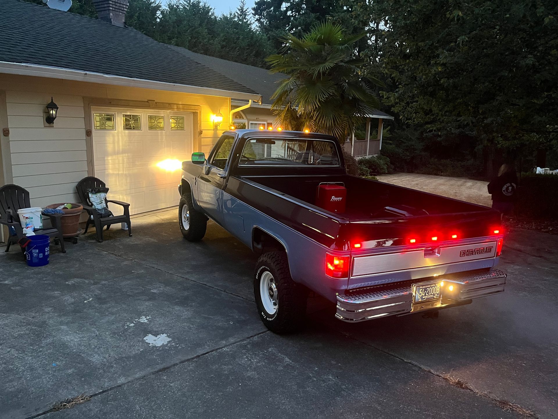 A blue truck is parked in front of a house.