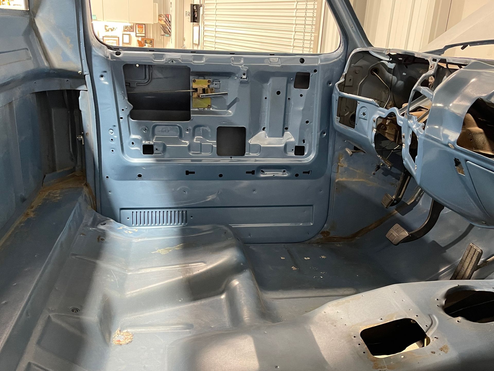 The inside of a blue truck is being restored.