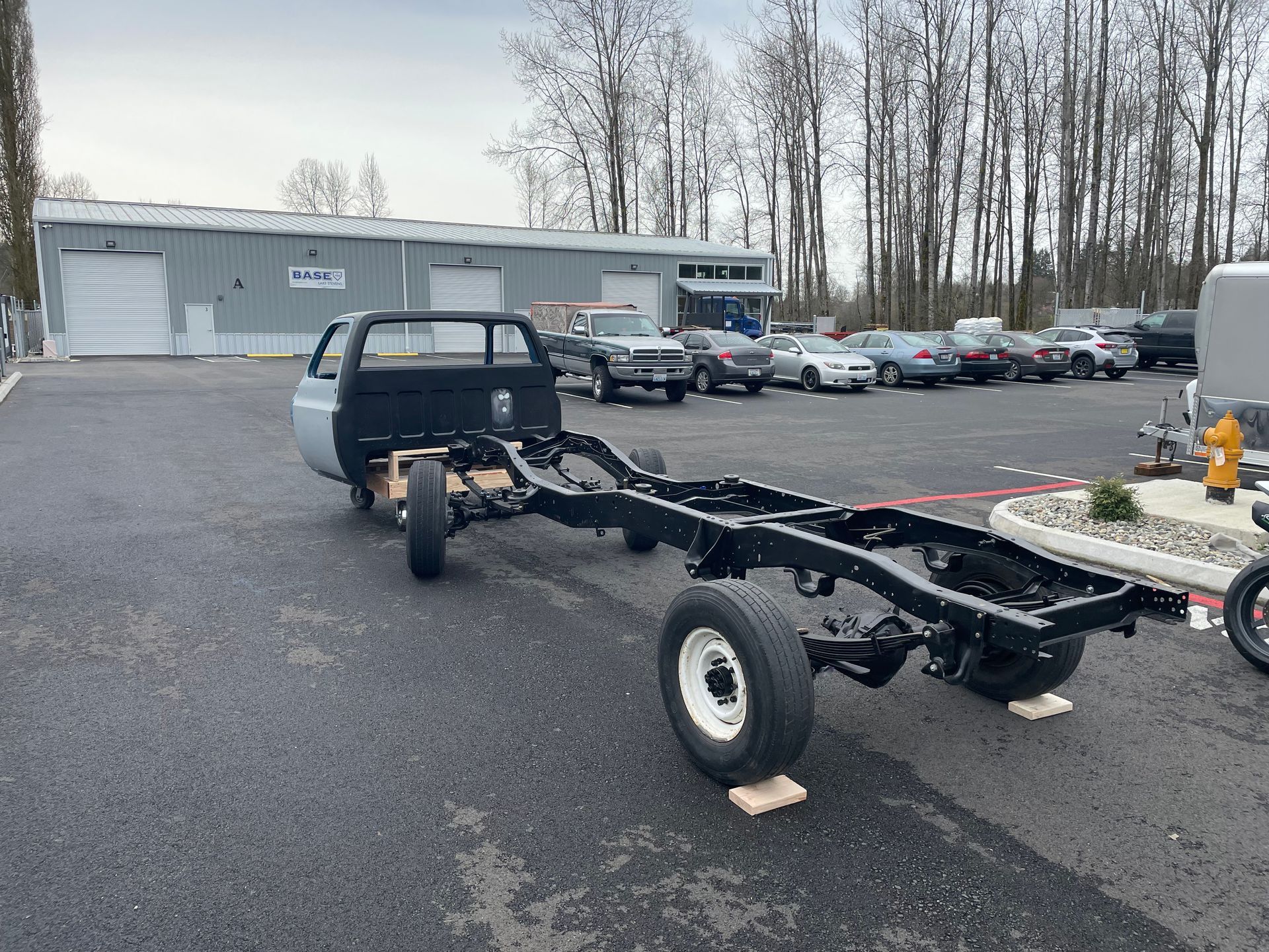 A truck with a trailer attached to it is parked in a parking lot.