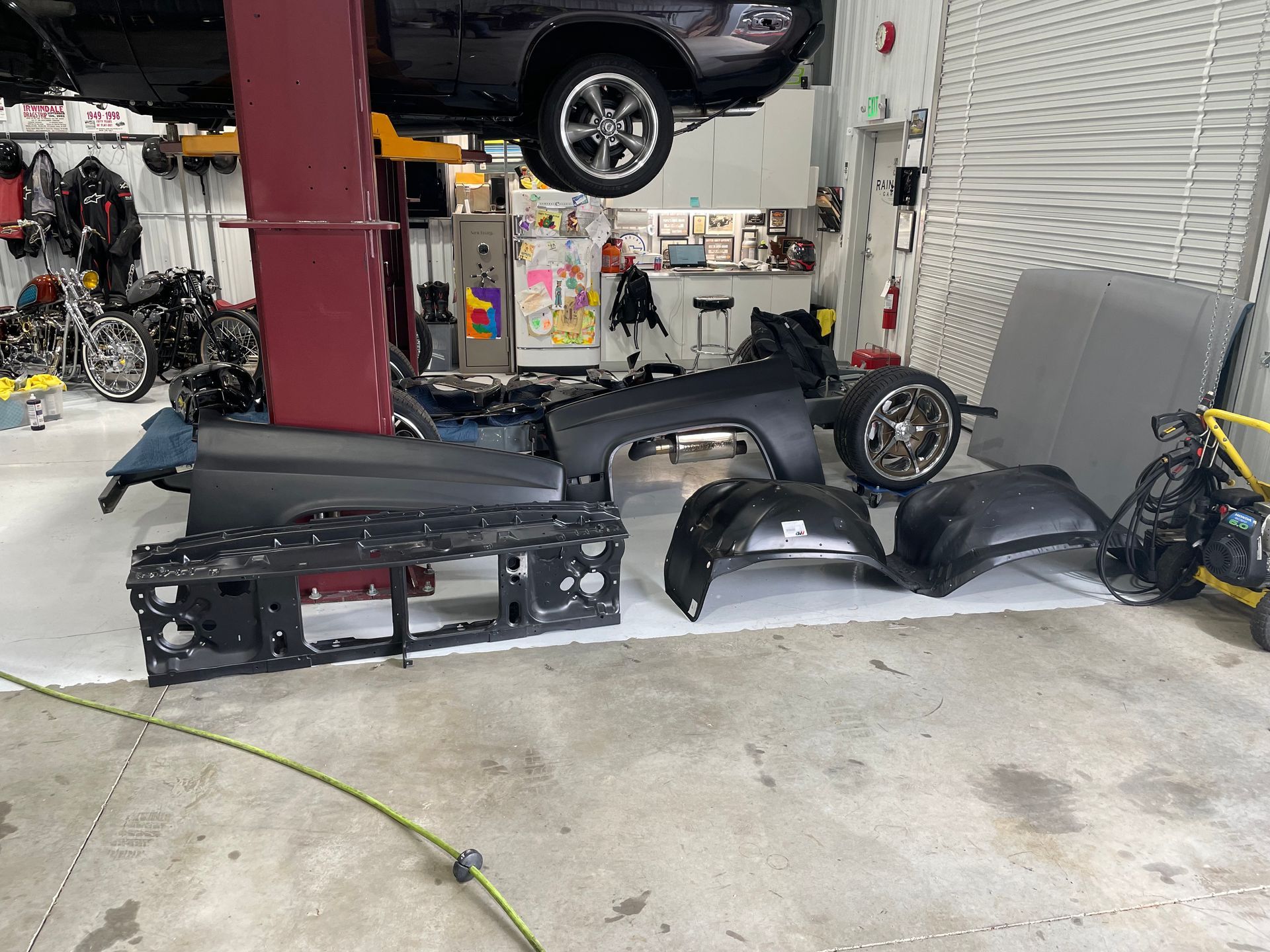 A car is sitting on a lift in a garage.