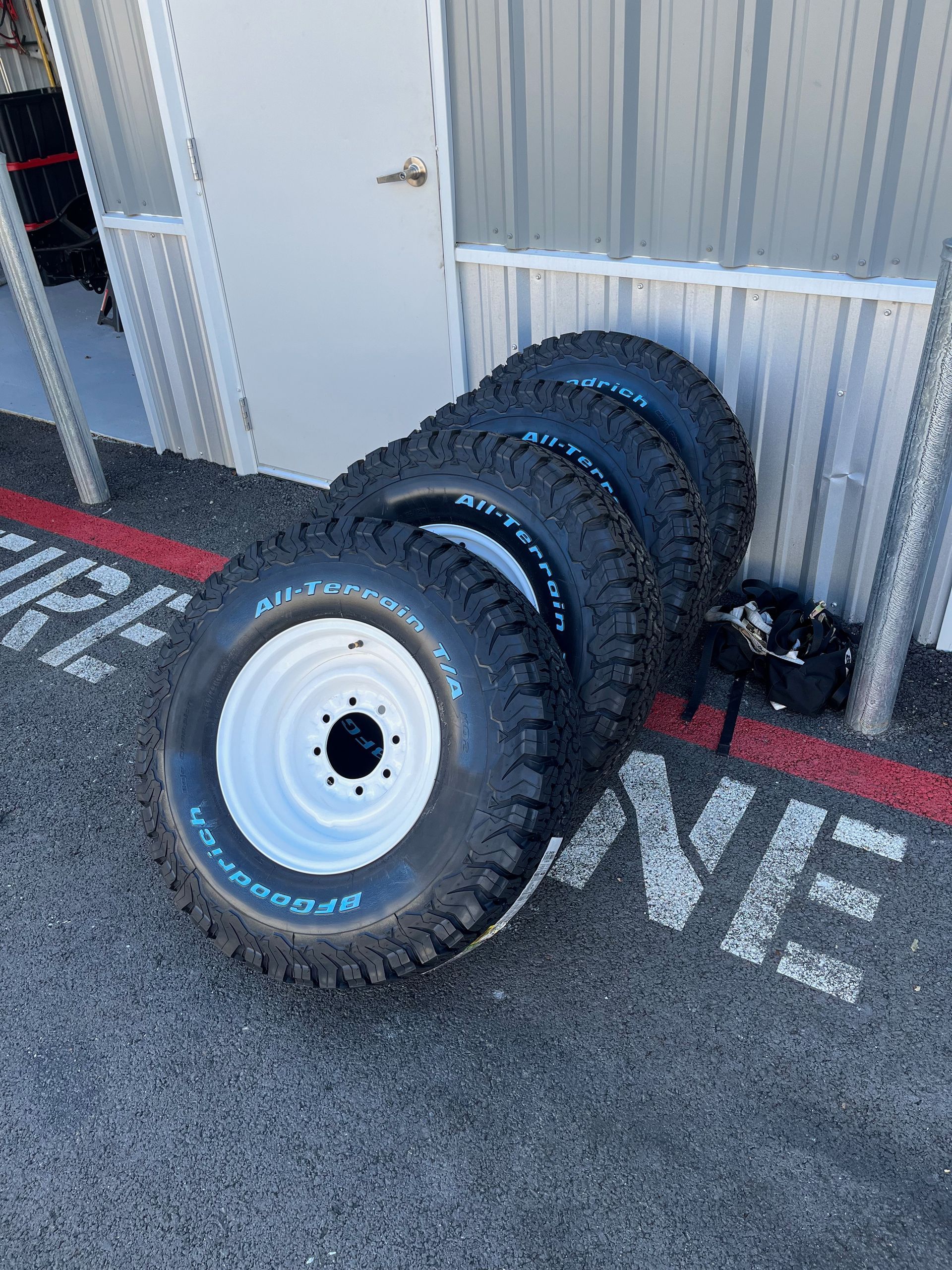 A bunch of tires are stacked on top of each other in front of a building.
