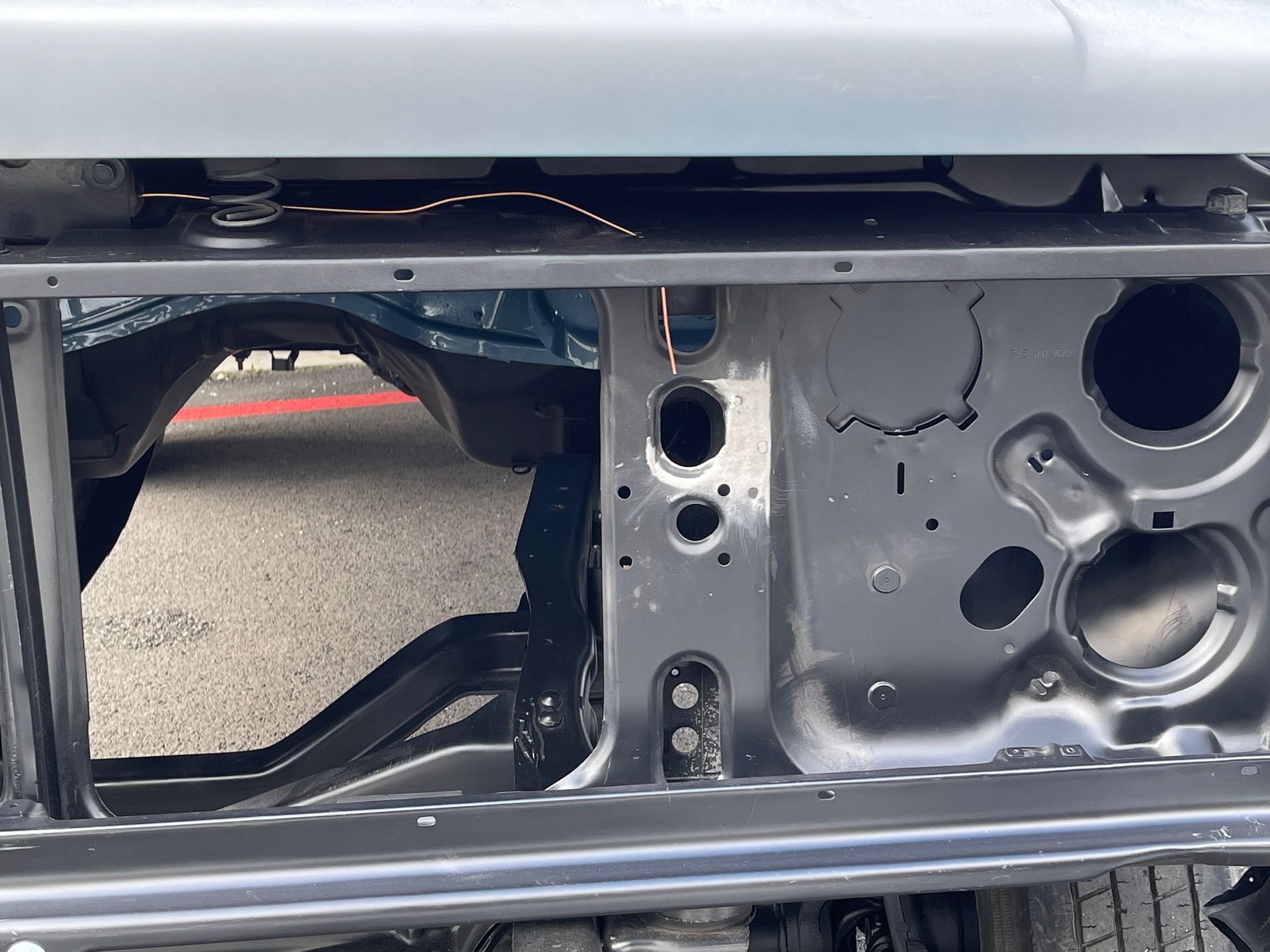 A close up of the underside of a car with holes in it.