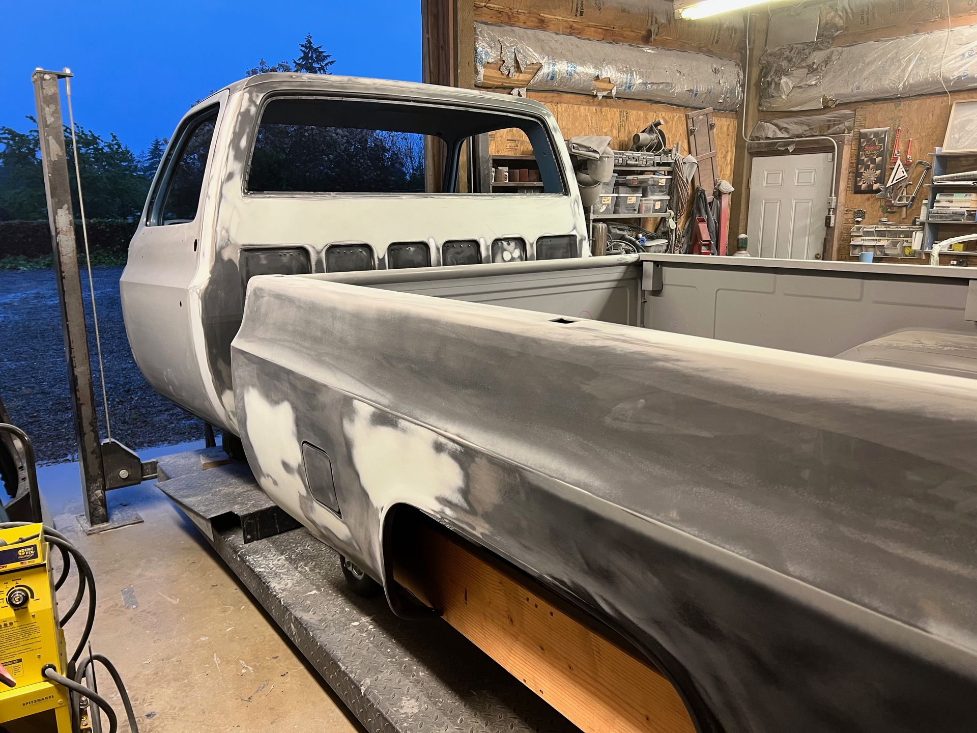 A white truck is sitting on a ramp in a garage.