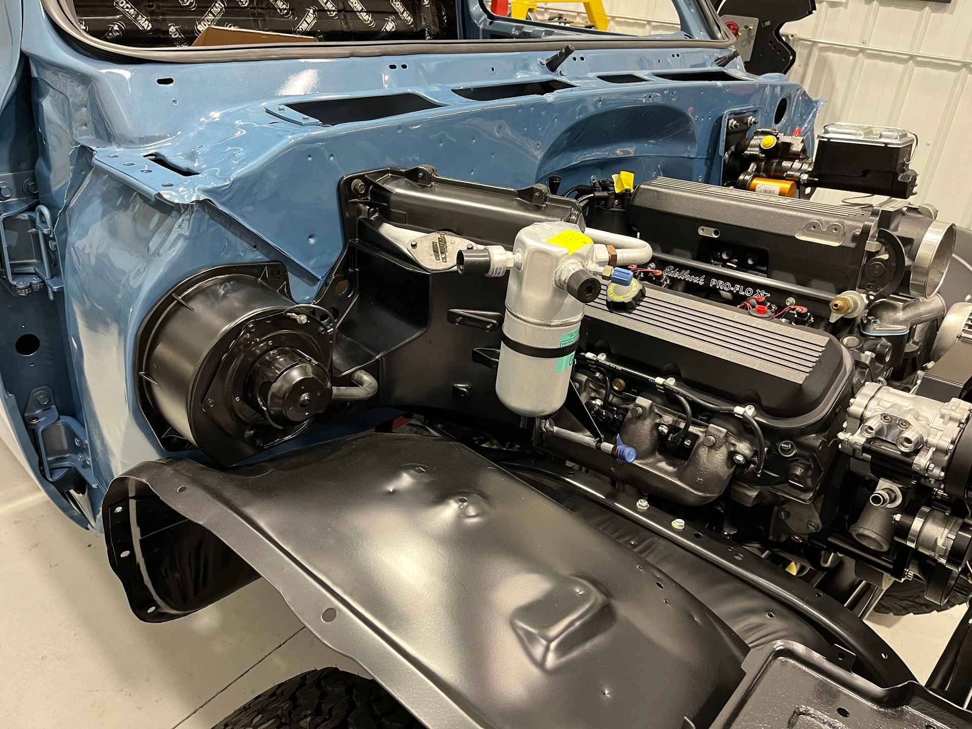 A close up of a car engine in a garage.