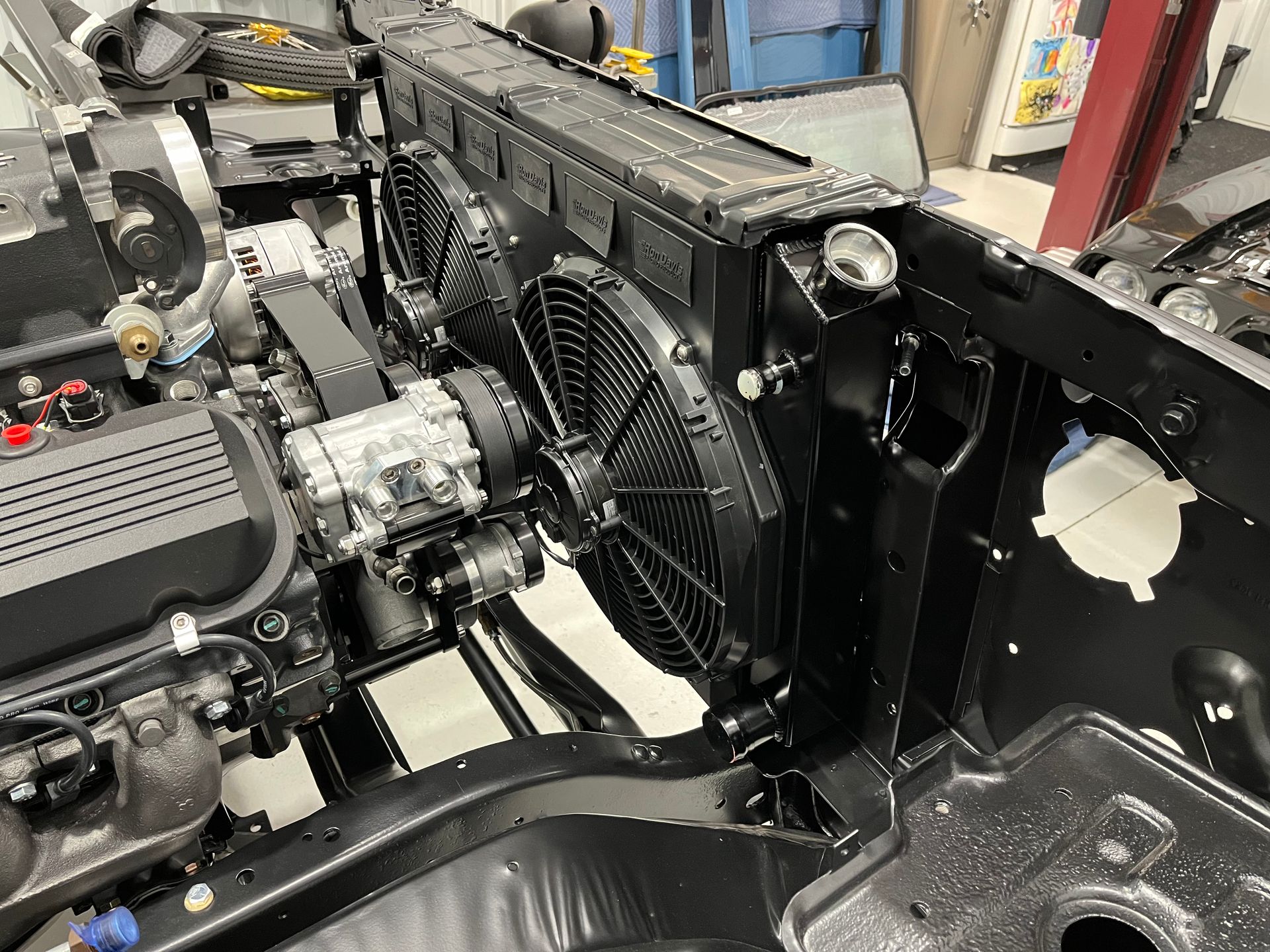 A close up of a car engine with a radiator and fans.