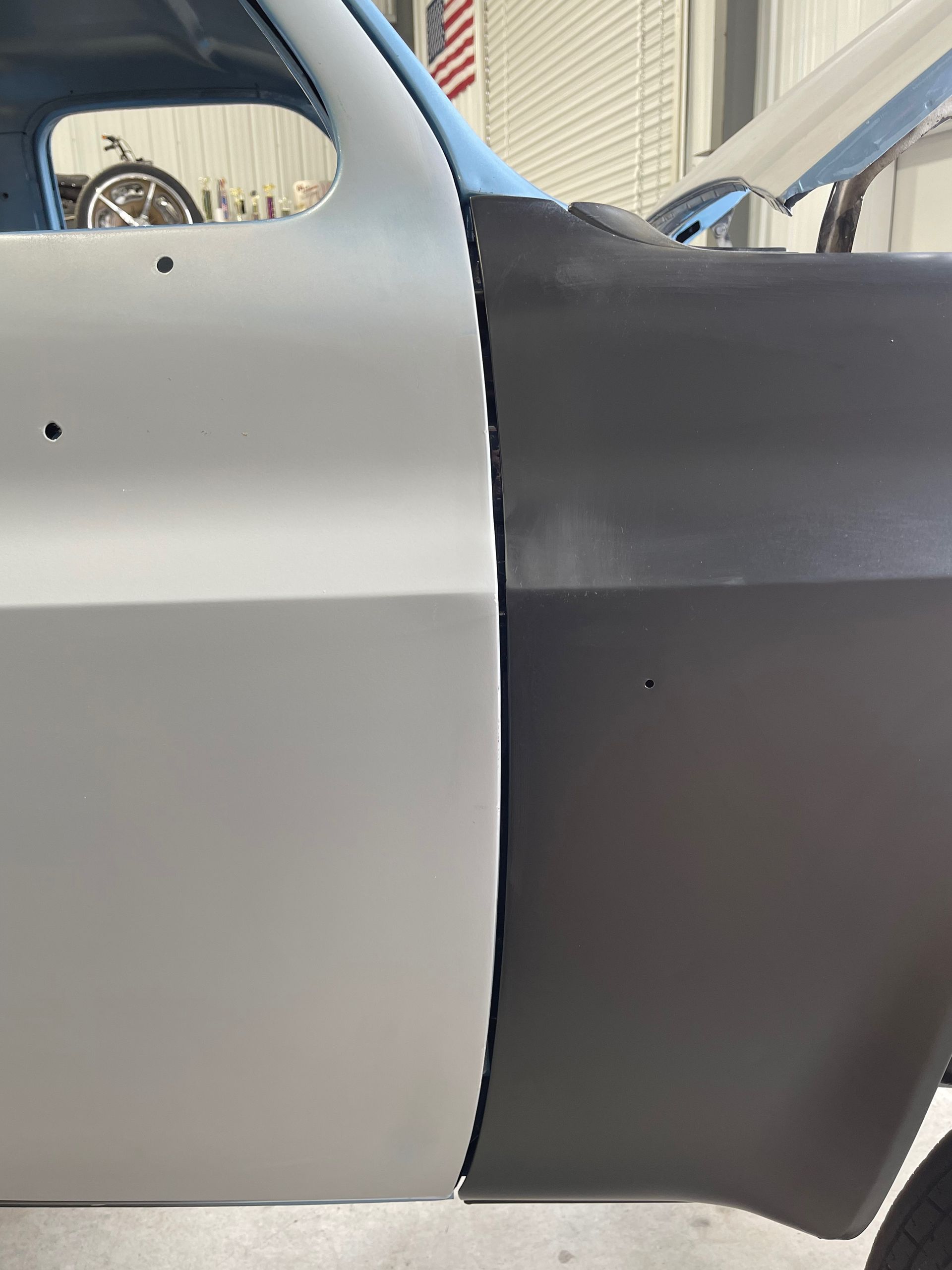 A car is being painted half white and half black.