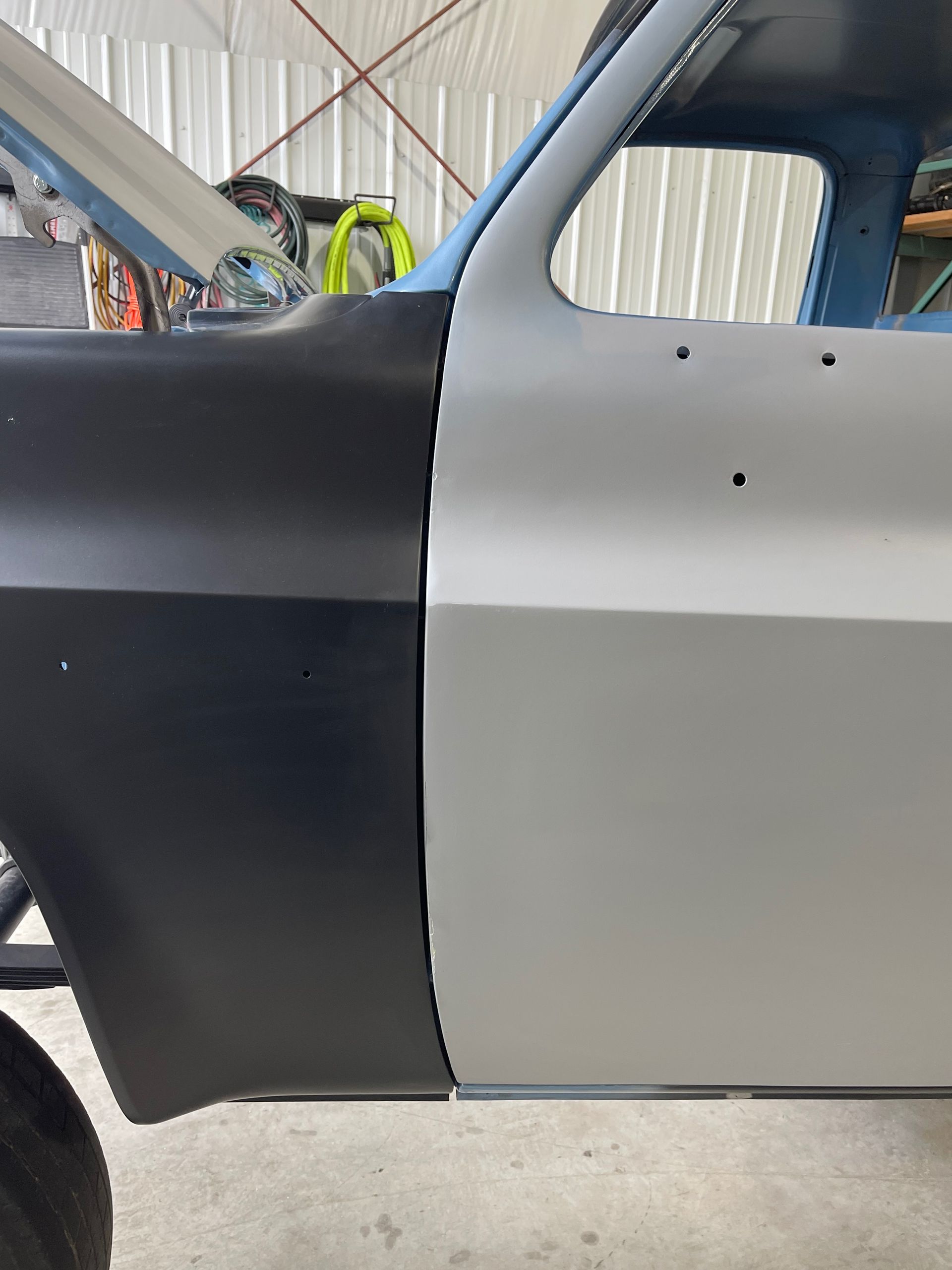 A black and white car is sitting in a garage.