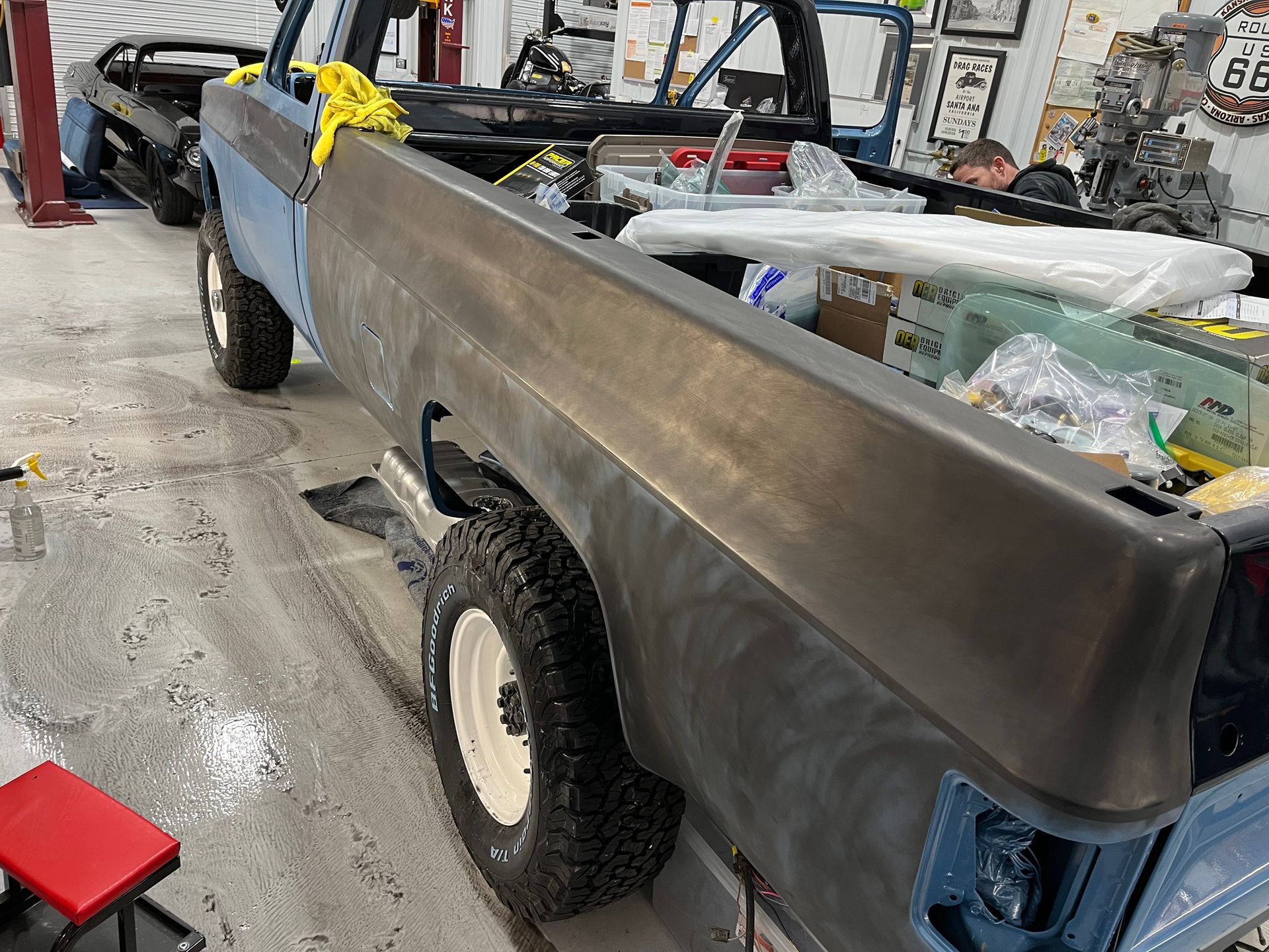 A truck is sitting on a lift in a garage.