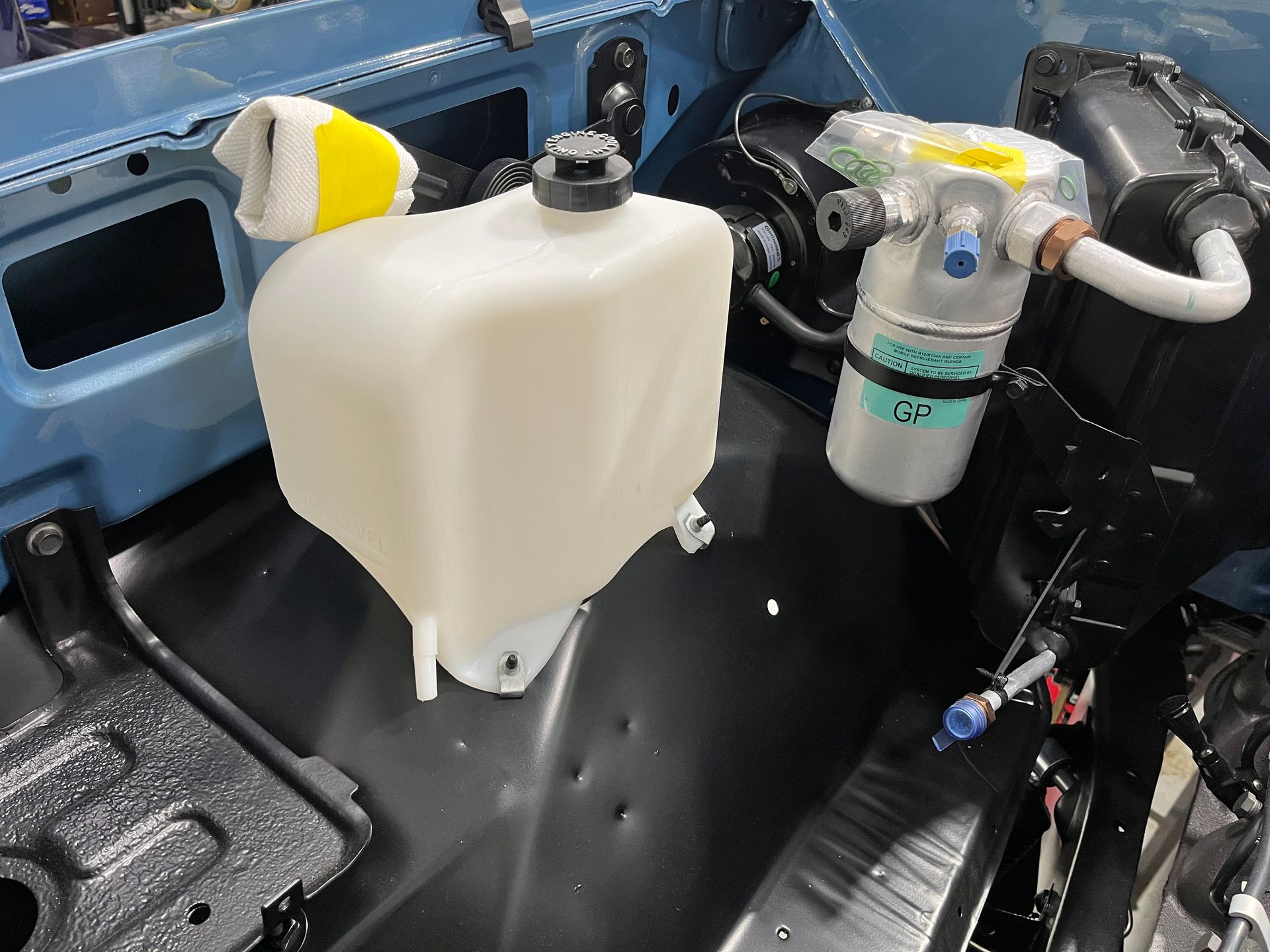 A white tank is sitting in the trunk of a car