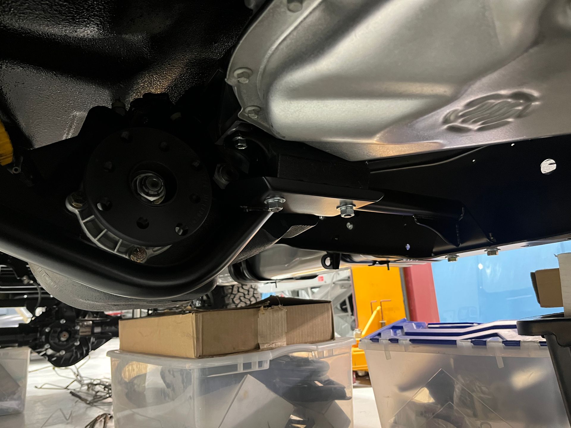 A close up of the underside of a car in a garage.